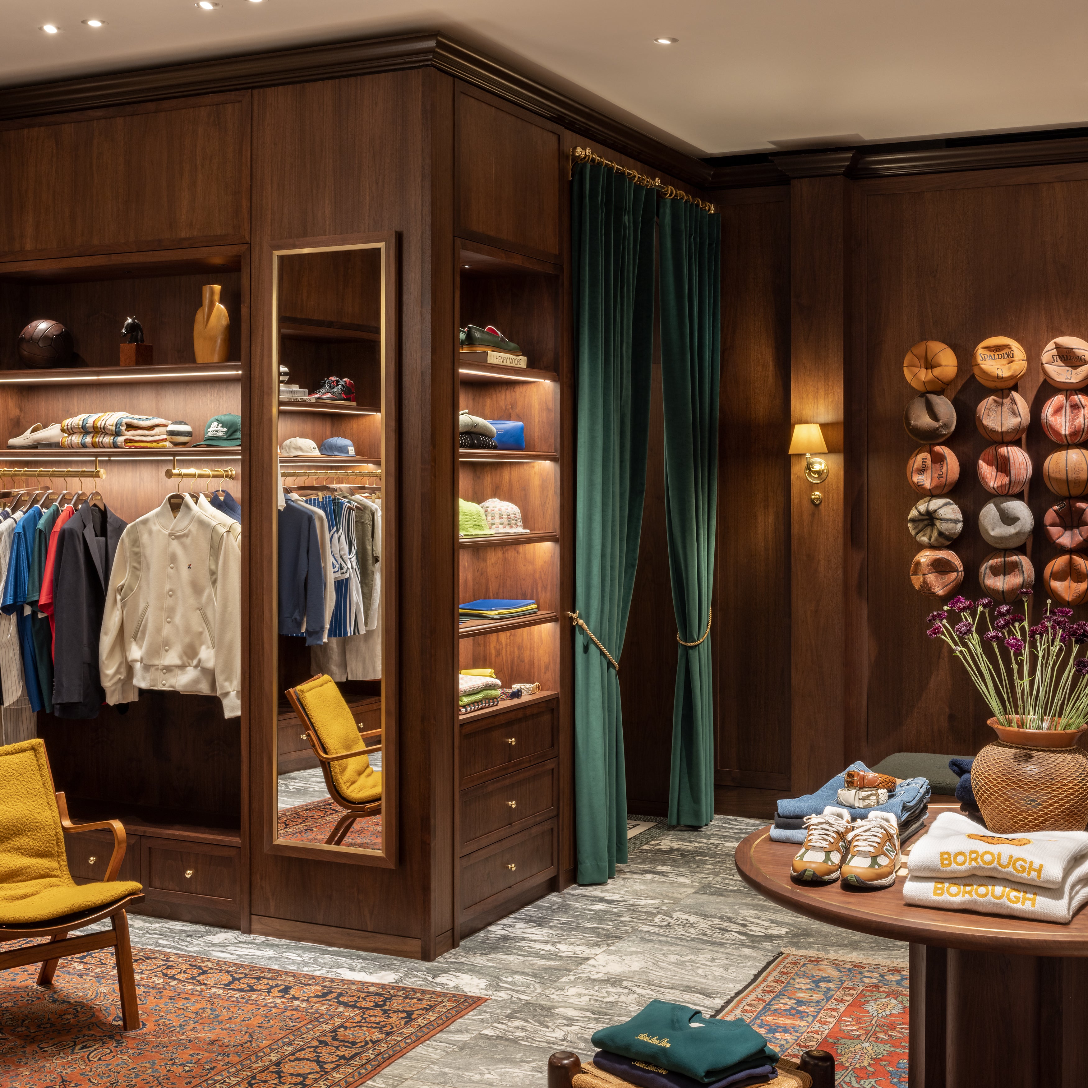 Third interior view with clothing setup and partial view of basketball wall at London flagship store 