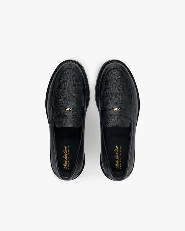 Top view of Lug Sole Queens Crest Loafer in black leather with gold insole text, shown on a light background.