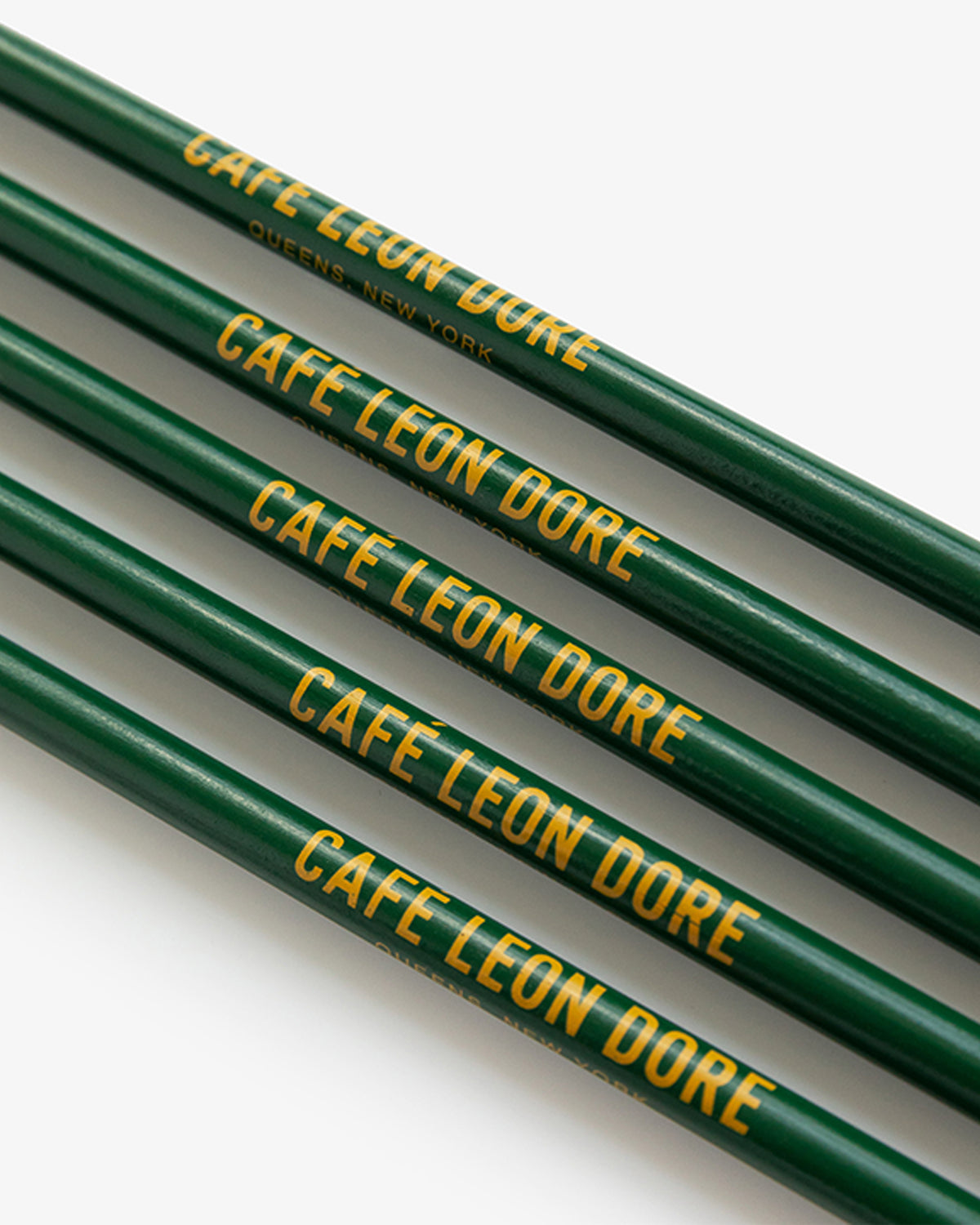 The Café Leon Dore Pencil Pack includes four green pencils with yellow text, one marked QUEENS, NEW YORK.
