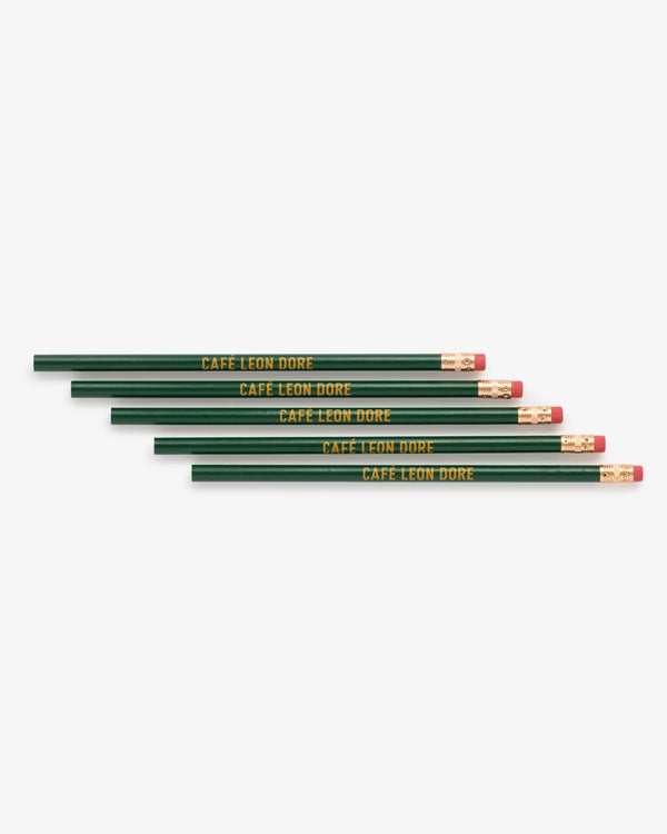 Five green Café Leon Dore pencils with erasers, each labeled in yellow, arranged in a row.