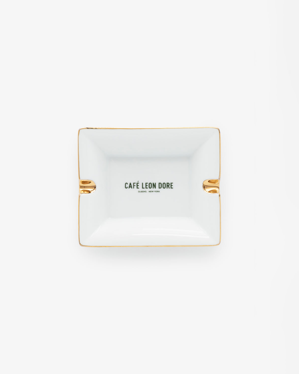 Café Leon Dore Ashtray—rectangular white with gold accents and CAFÉ LEON DORE text centered, on a plain background.