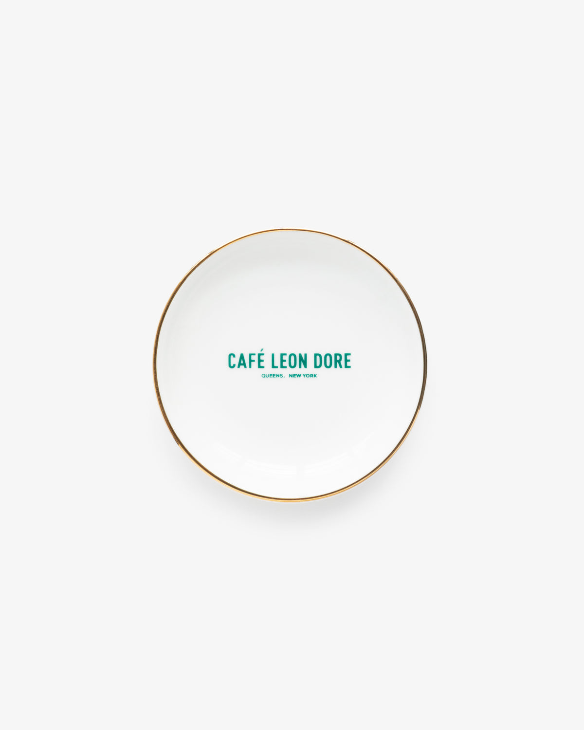 Café Leon Dore Ring Dish: white plate with gold rim, green “CAFÉ LEON DORE, QUEENS, NEW YORK” in center.