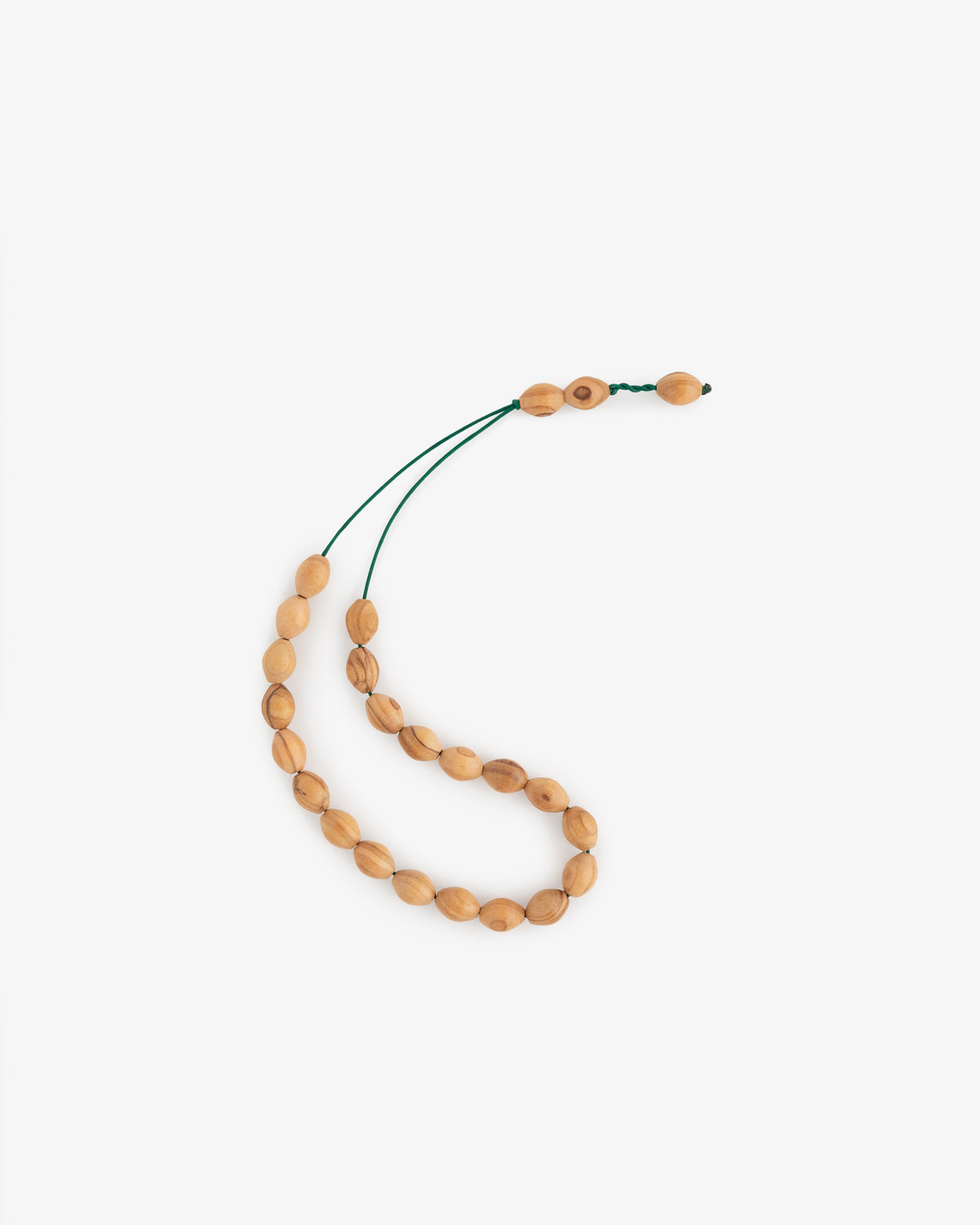 The Café Leon Dore Komboloi is a wooden oval bead string with a dark green cord on a white background.