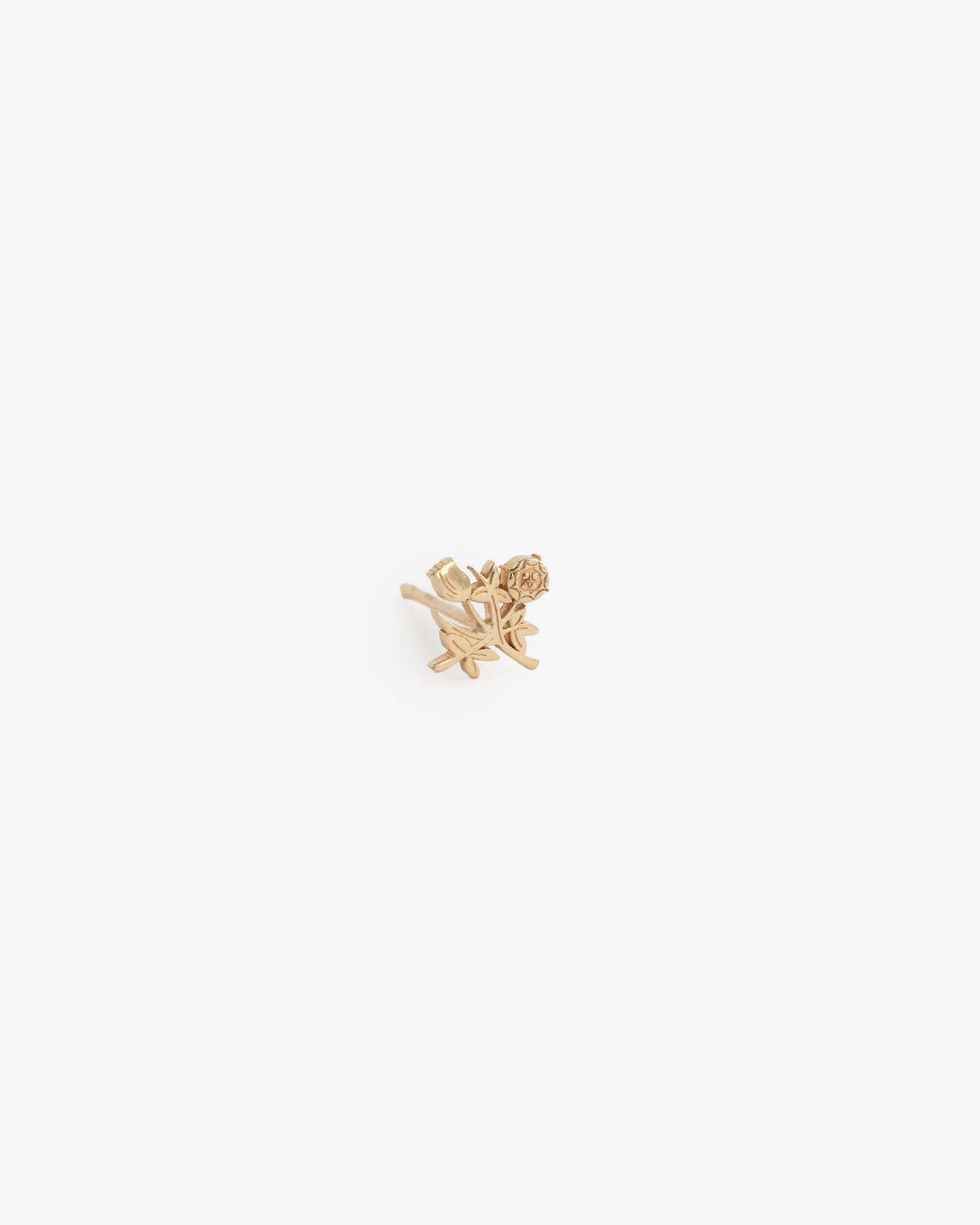 The 14Kt Gold Crest Earring is a small gold stud shaped like a rose with stem and leaves, shown on a white background.