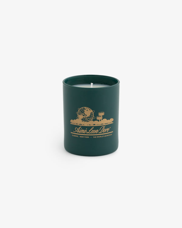 Unisphere Candle in matte glass holder with gold globe and text design, shown on a plain white background.