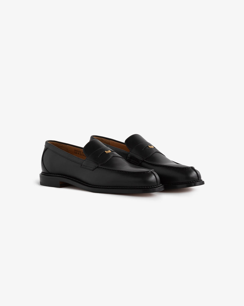 Queens Crest Loafer: black leather loafers with low heels and stitching details, shown on a white background.