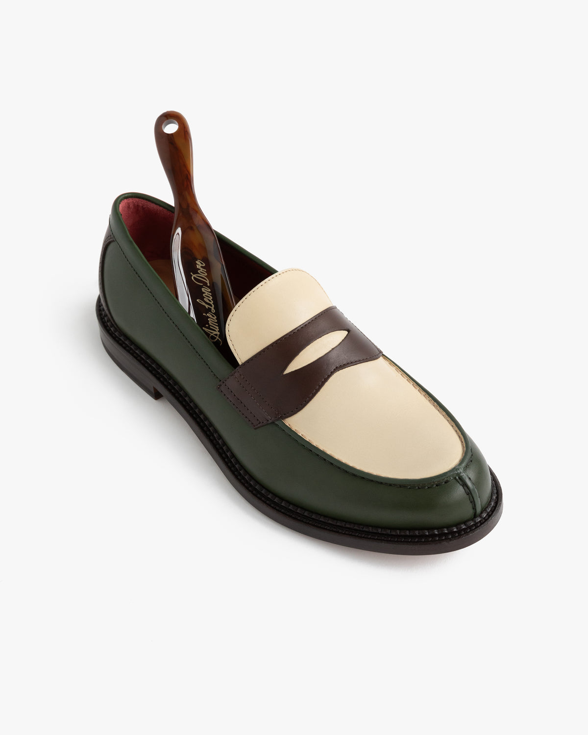 Queens Crest Loafer in green, cream, and brown leather with shoehorn, shown on a white background.
