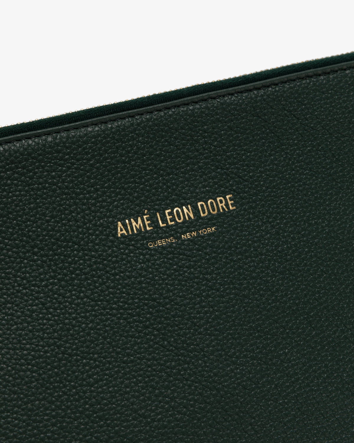 Close-up of Medium Leather Pouch in black textured leather with gold text: AIMÉ LEON DORE QUEENS, NEW YORK.