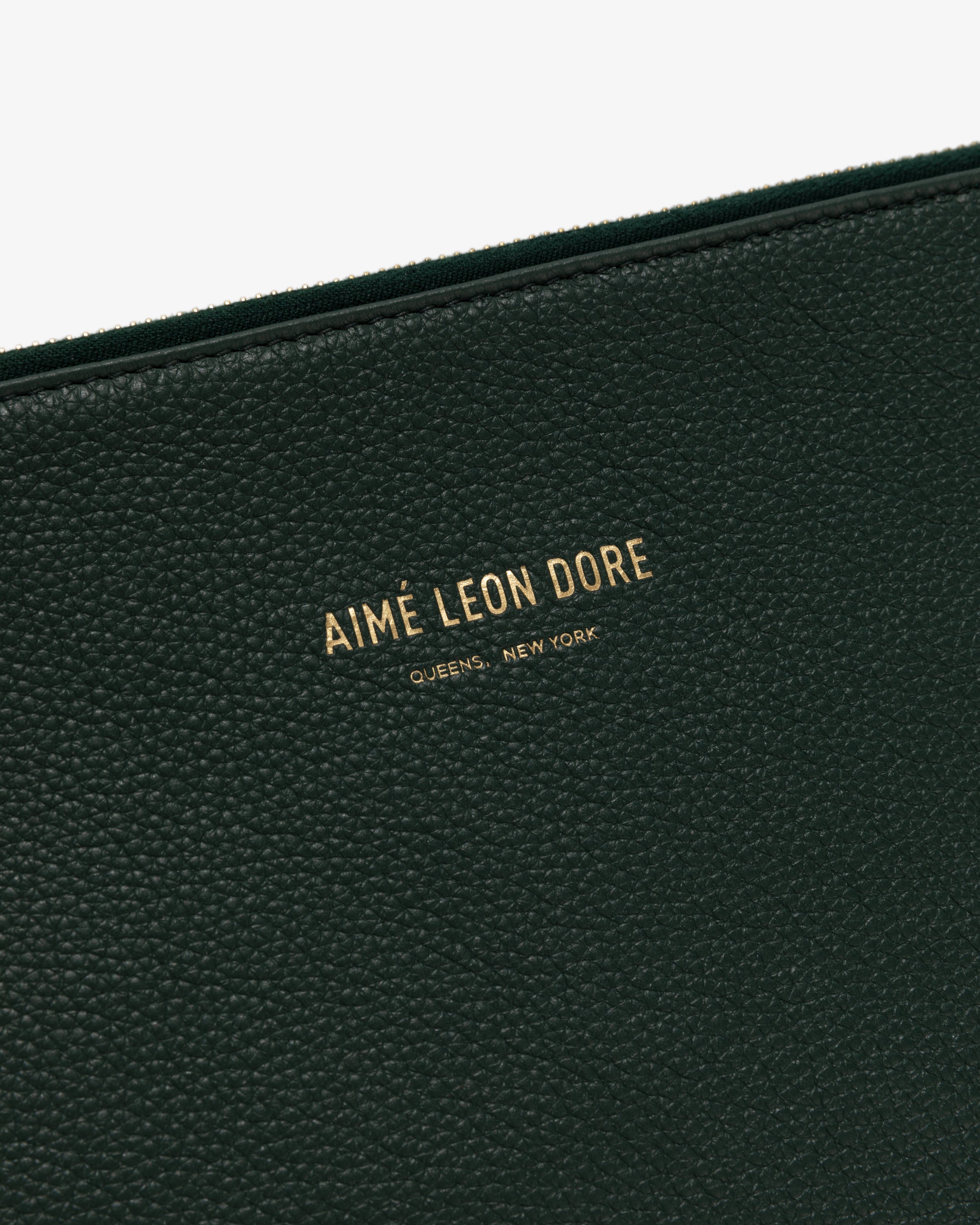 Close-up of Medium Leather Pouch in black textured leather with gold text: AIMÉ LEON DORE QUEENS, NEW YORK.