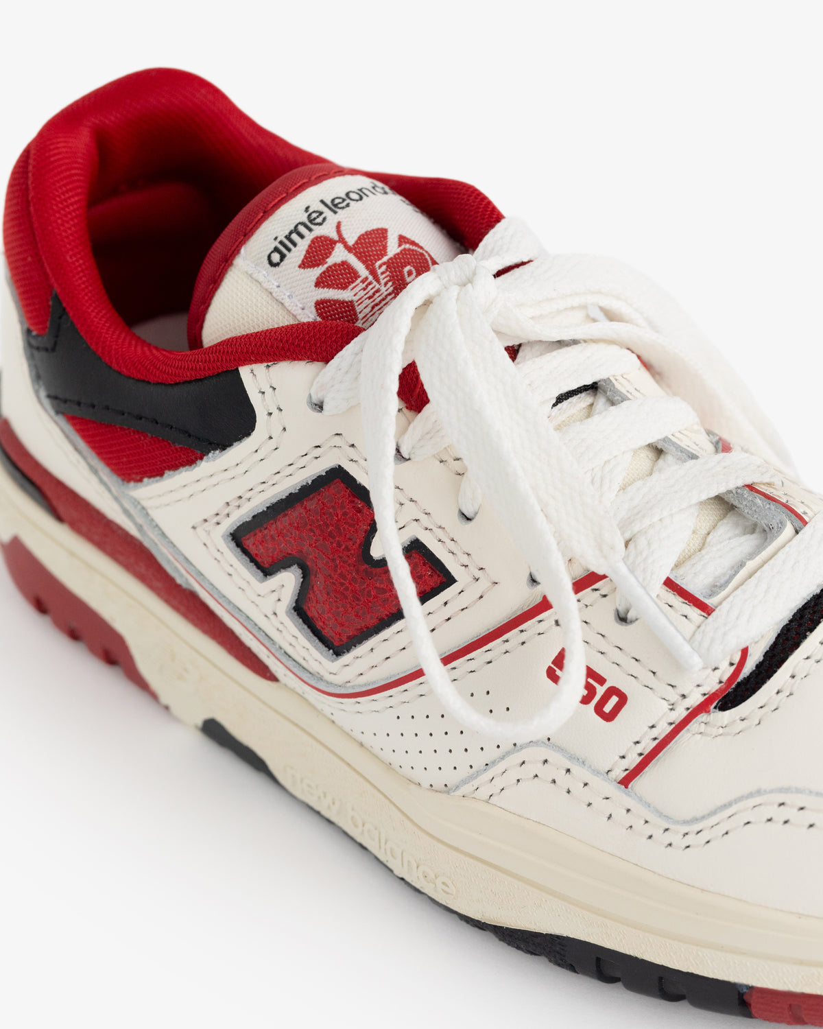 Cream and red ALD / NB P550 Basketball Oxfords—Little Kids, black accents, white laces, red sole, branded tongue.