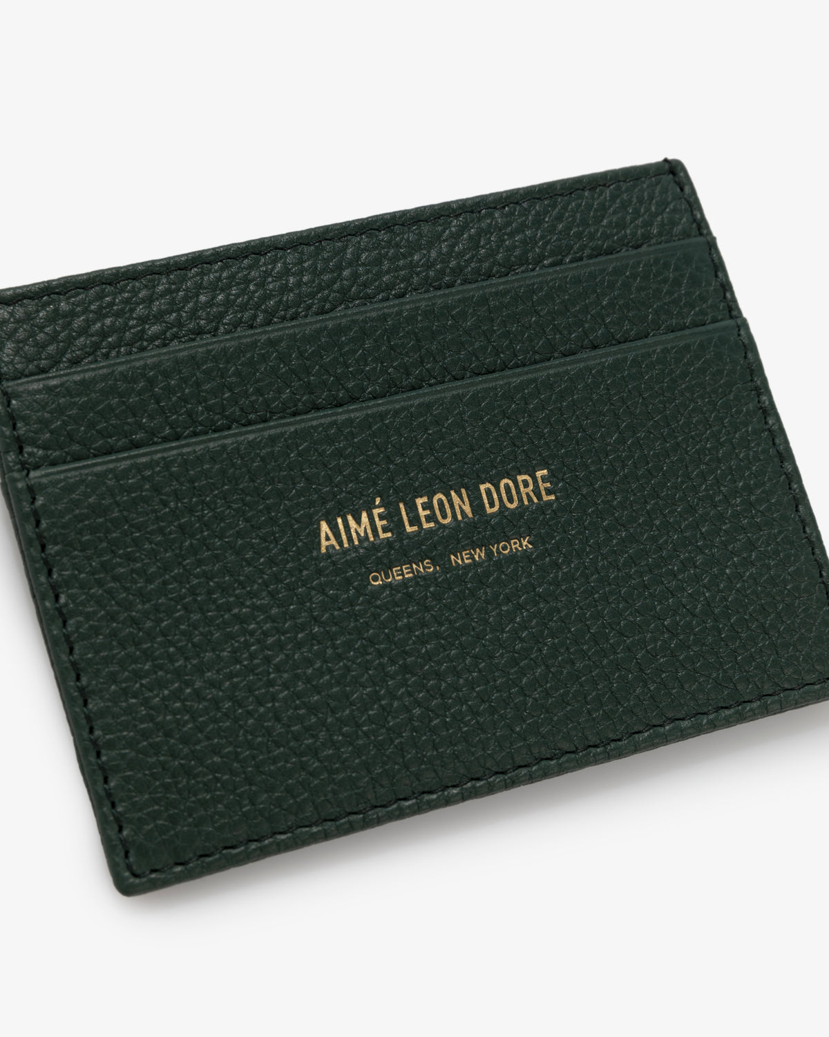 Dark green Leather Card Holder with gold AIMÉ LEON DORE QUEENS, NEW YORK text and three card slots.