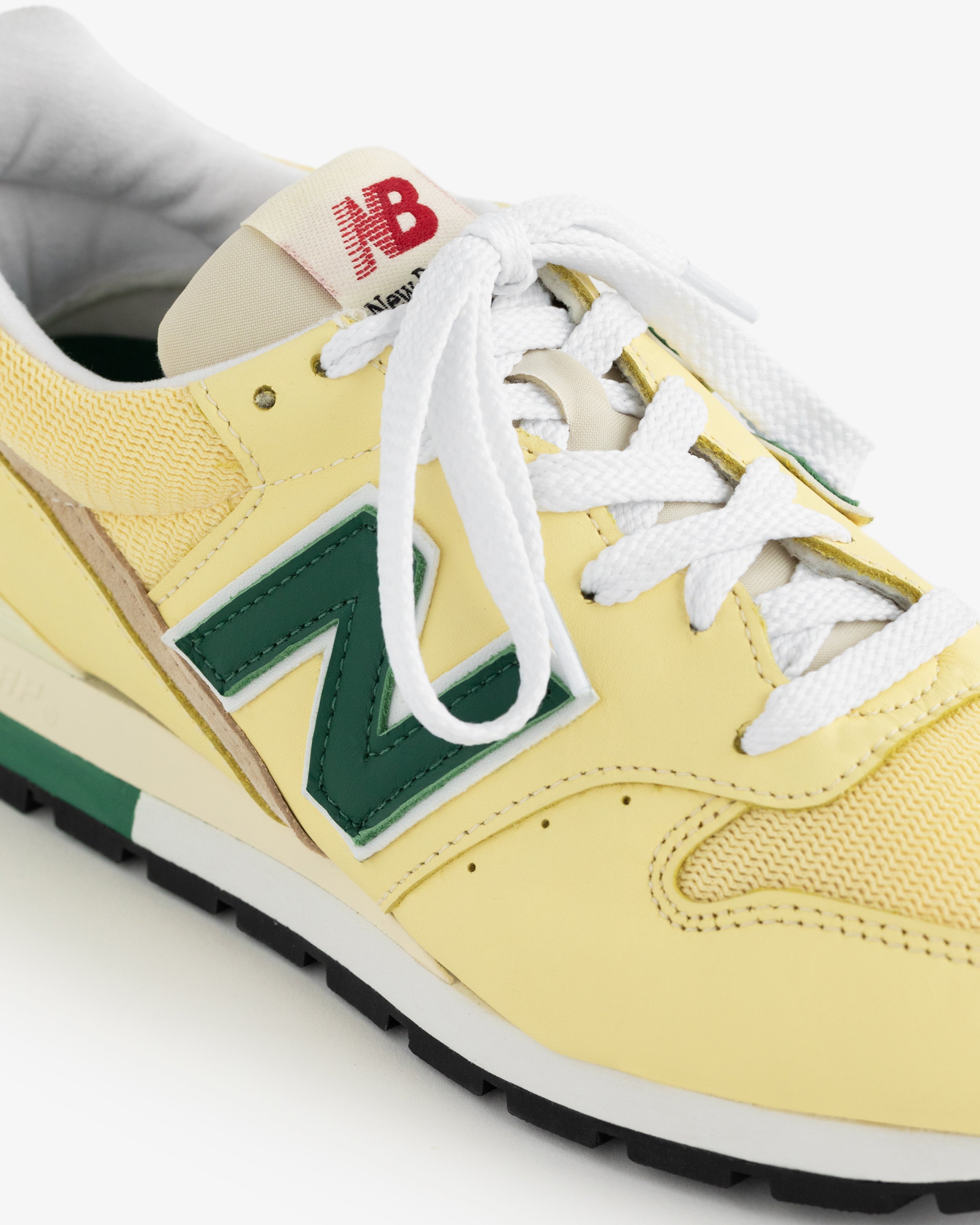 Yellow New Balance Made in USA 996 with green N logo, white laces, and red NB on the tongue, shown from above.