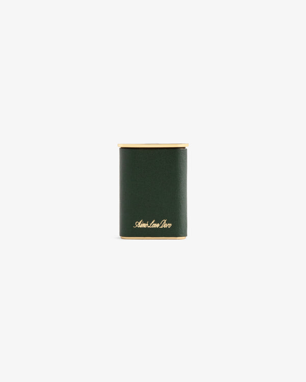 A dark green cylindrical Queens Crest Leather Portable Ashtray with gold accents and “Smythson” in gold script on front.