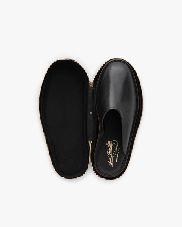A Leather Travel Slipper in a black oval zippered case, viewed from above on a white background.