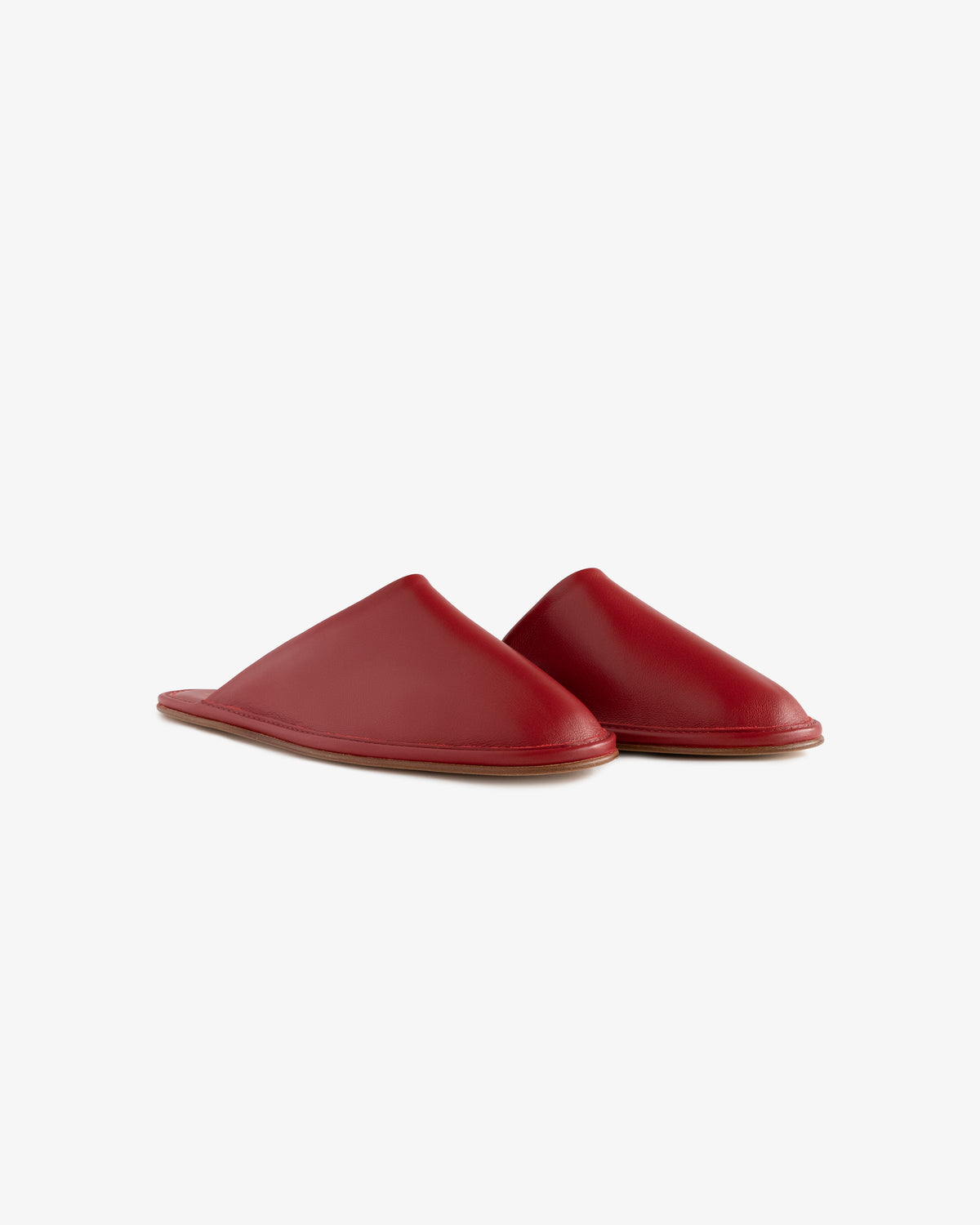 A pair of Leather Travel Slippers in red leather with flat brown soles, shown on a white background.
