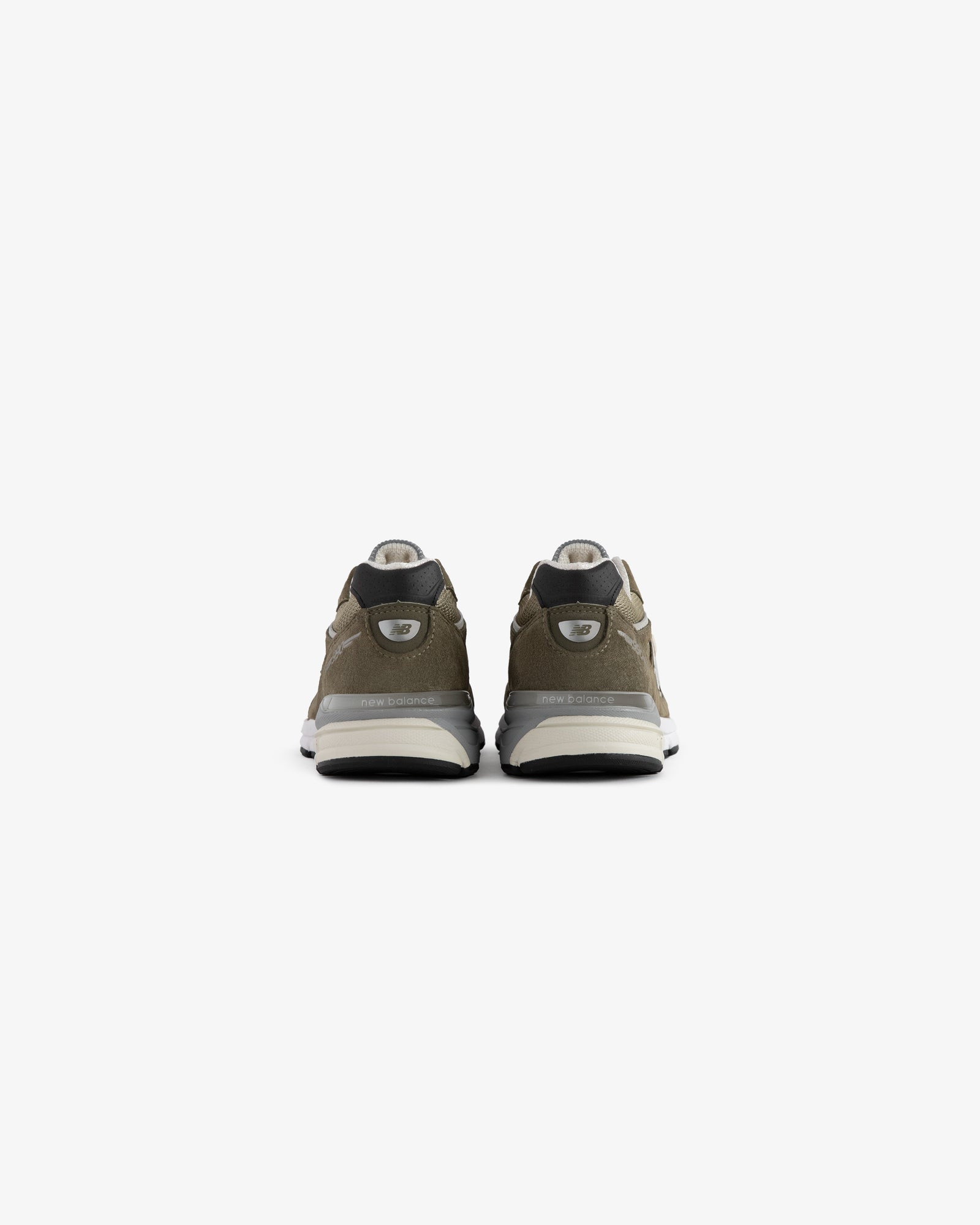 ALD / New Balance 990v4 olive green sneakers with white soles and black accents, shown from the back on white.