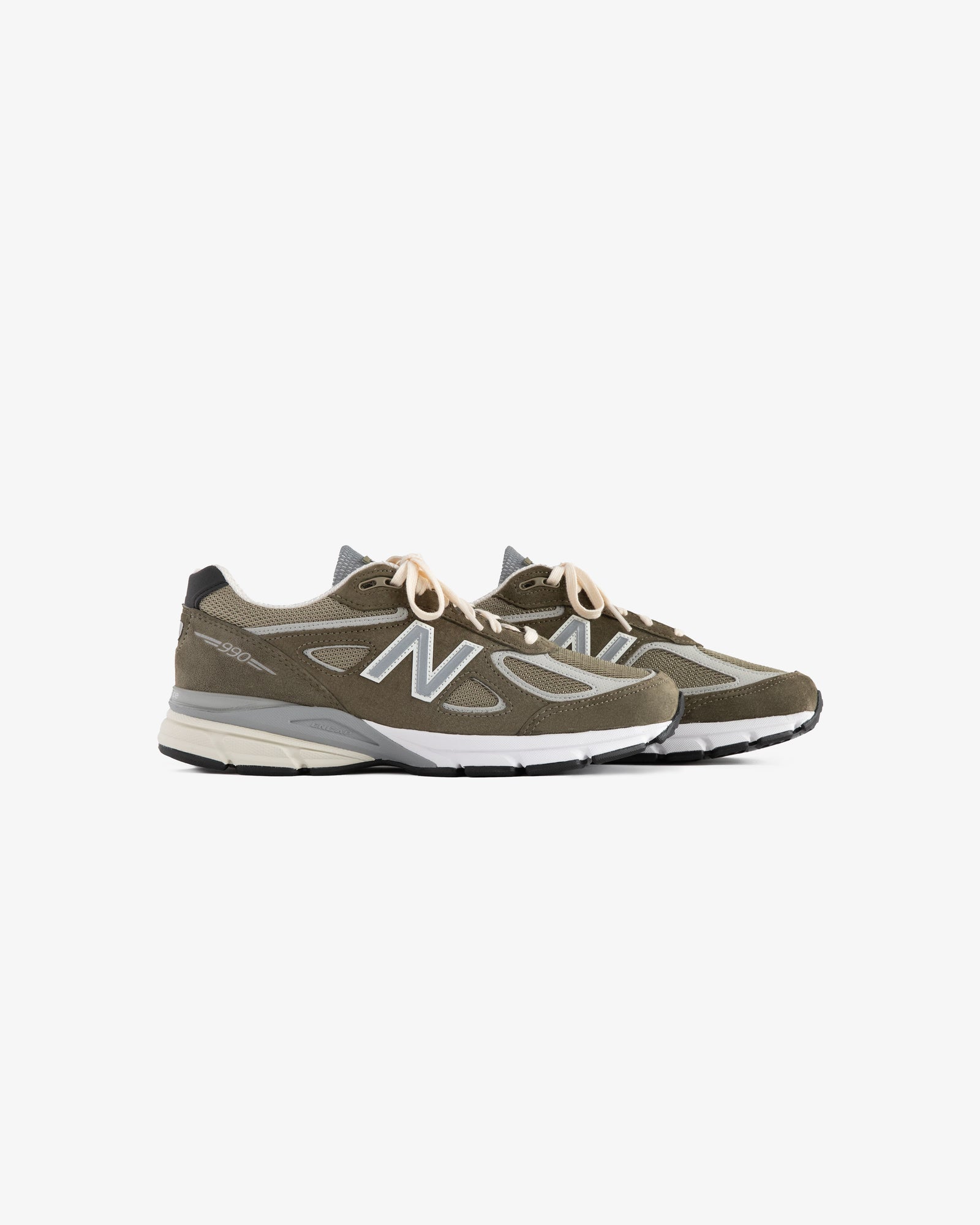 A pair of olive green ALD / New Balance 990v4 sneakers with white soles and beige laces on a white background.