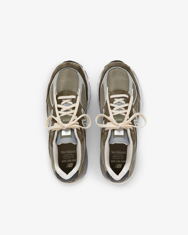 A pair of olive green and beige ALD / New Balance 990v4 sneakers viewed from above on a white background.