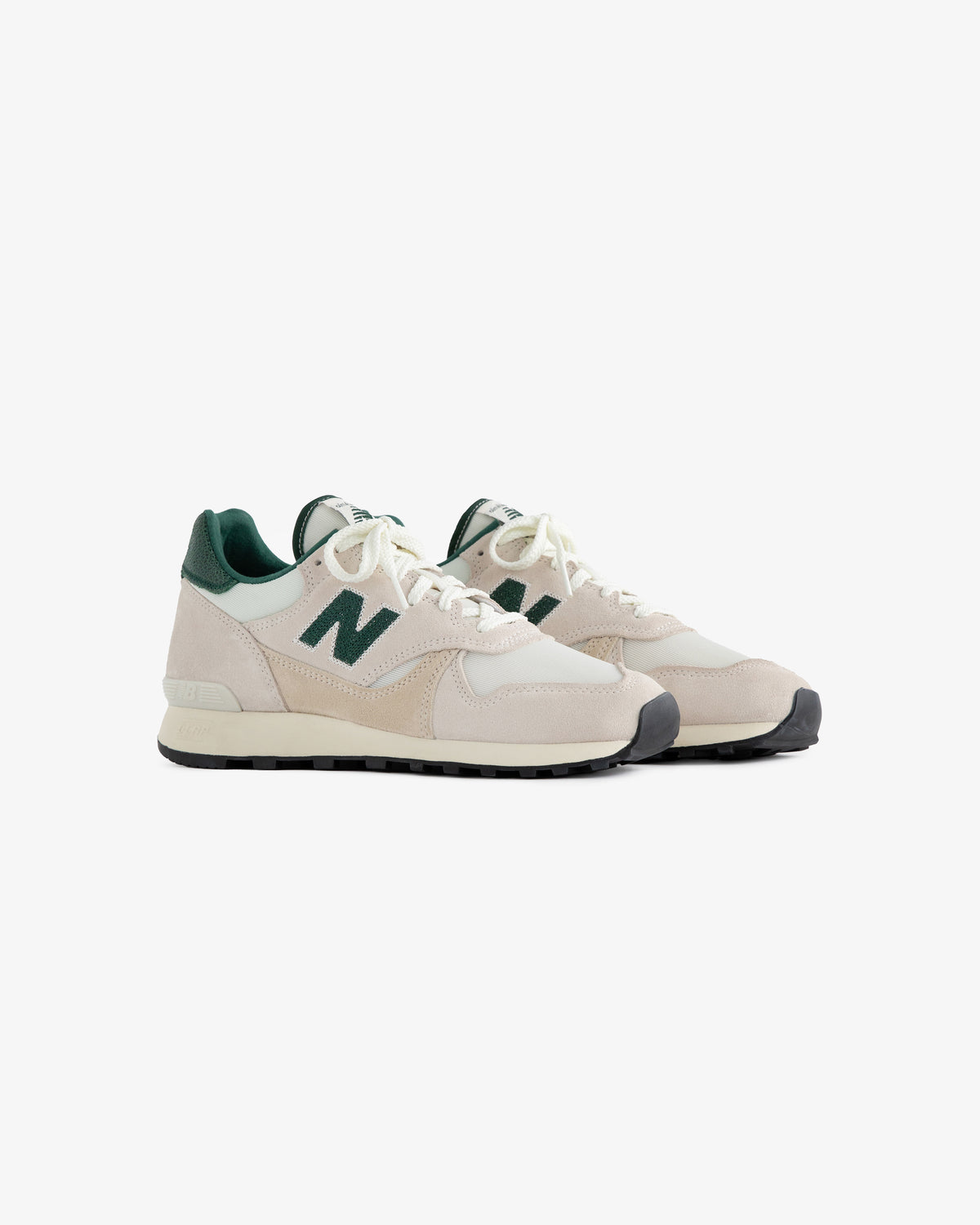 A pair of beige and green ALD / New Balance 475 sneakers with white laces on a plain white background.