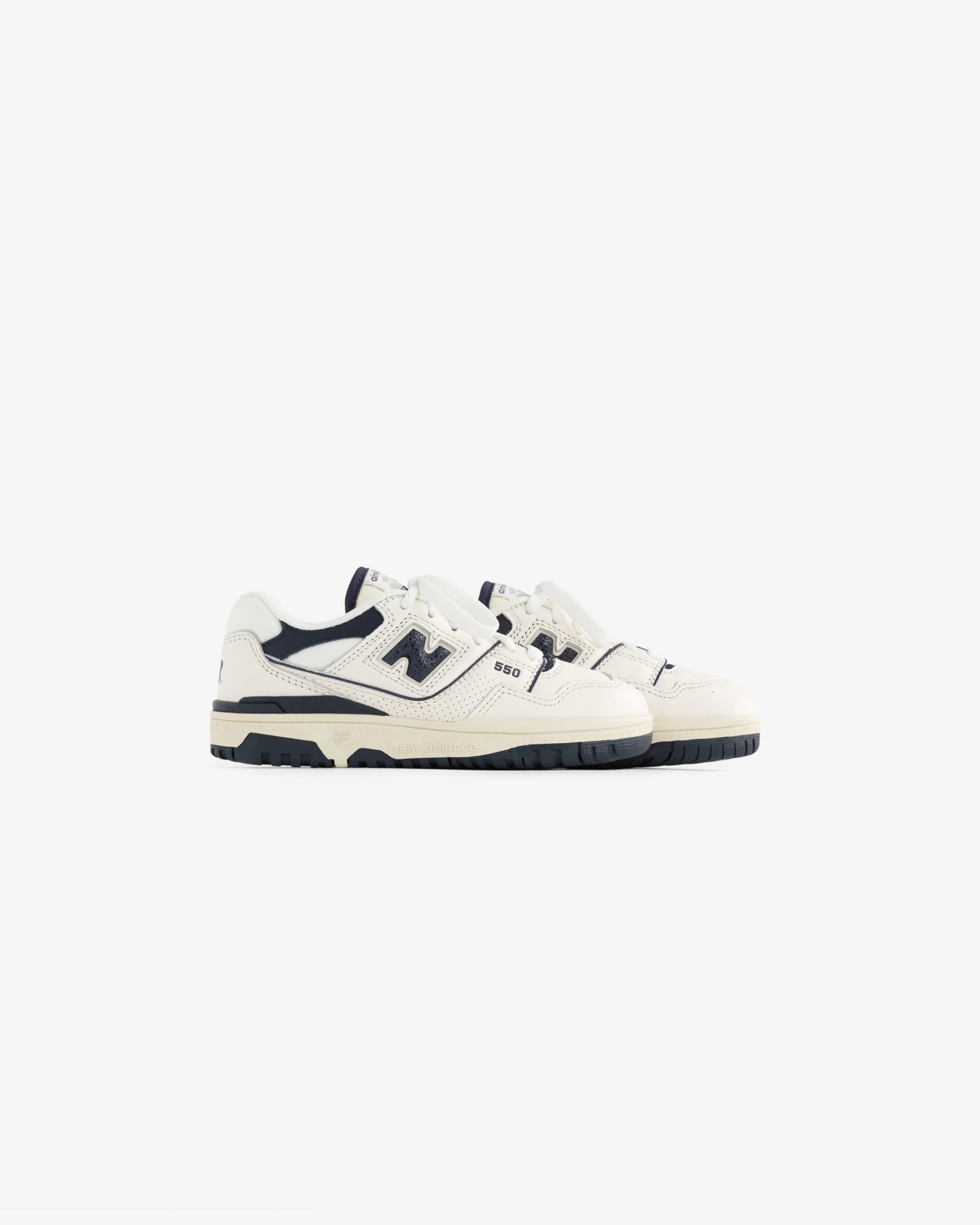 A pair of ALD / NB P550 Basketball Oxfords for little kids in white and navy on a plain white background.
