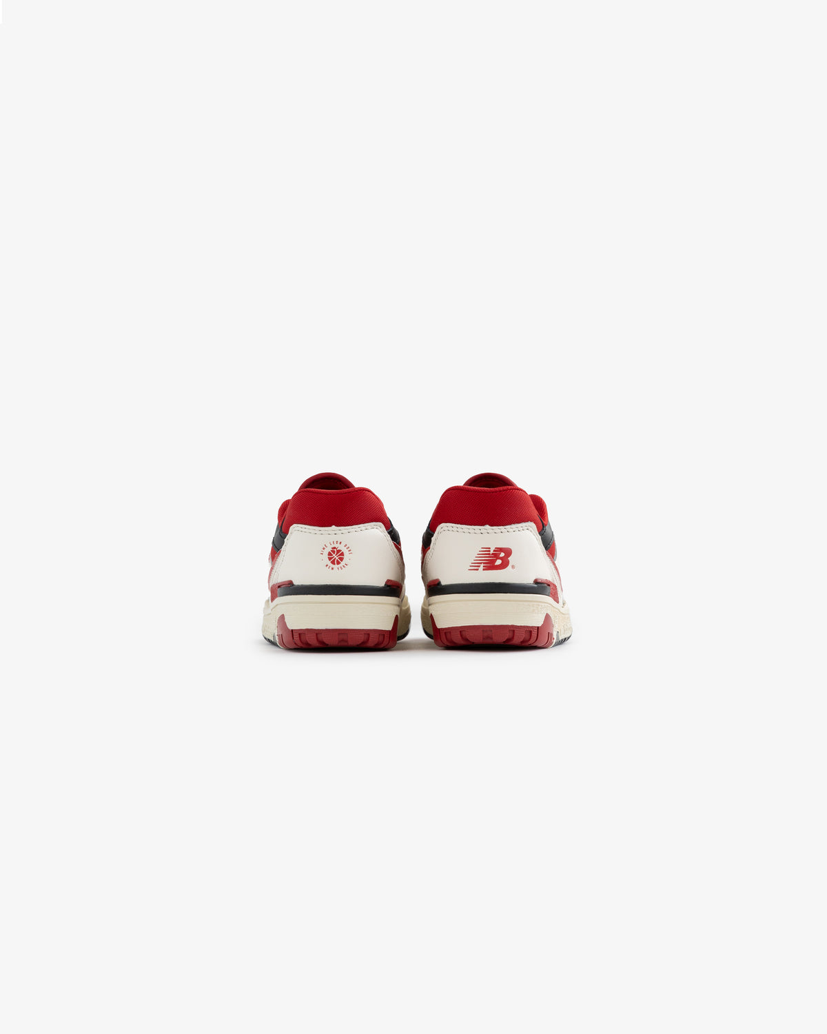 Back view of ALD / NB P550 Basketball Oxfords - Little Kids in white and red with heel logos on a plain white background.