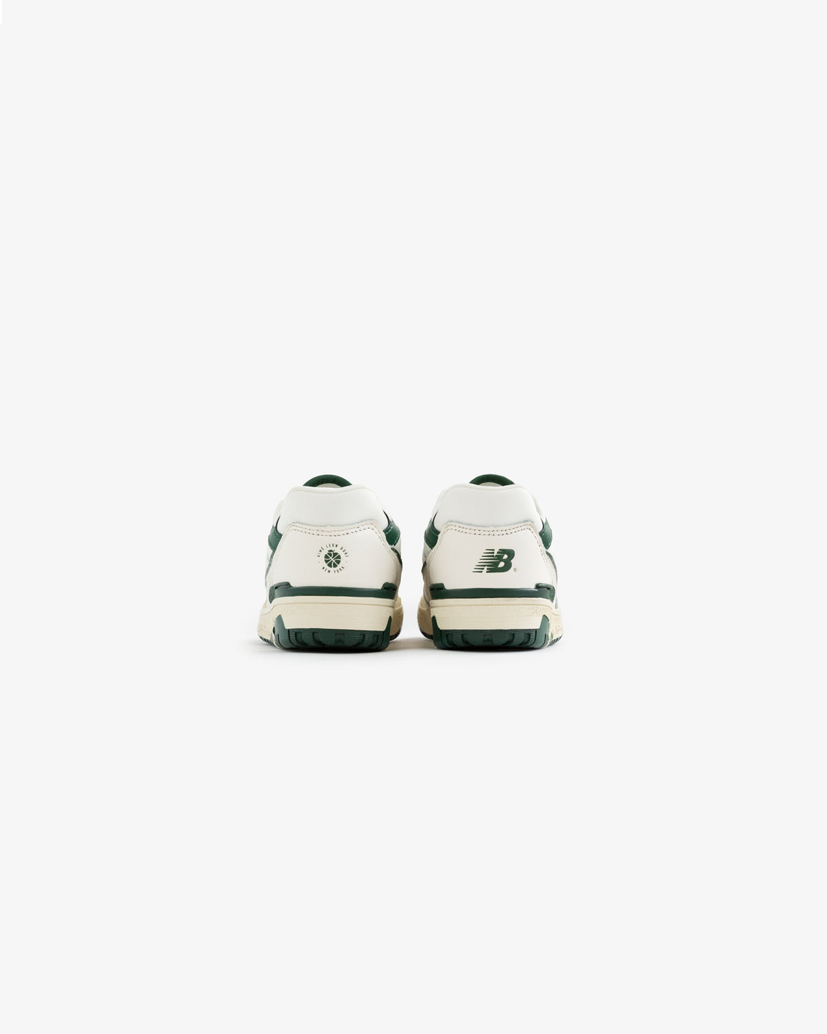 Back view of white and green ALD / NB P550 Basketball Oxfords for little kids on a plain white background.