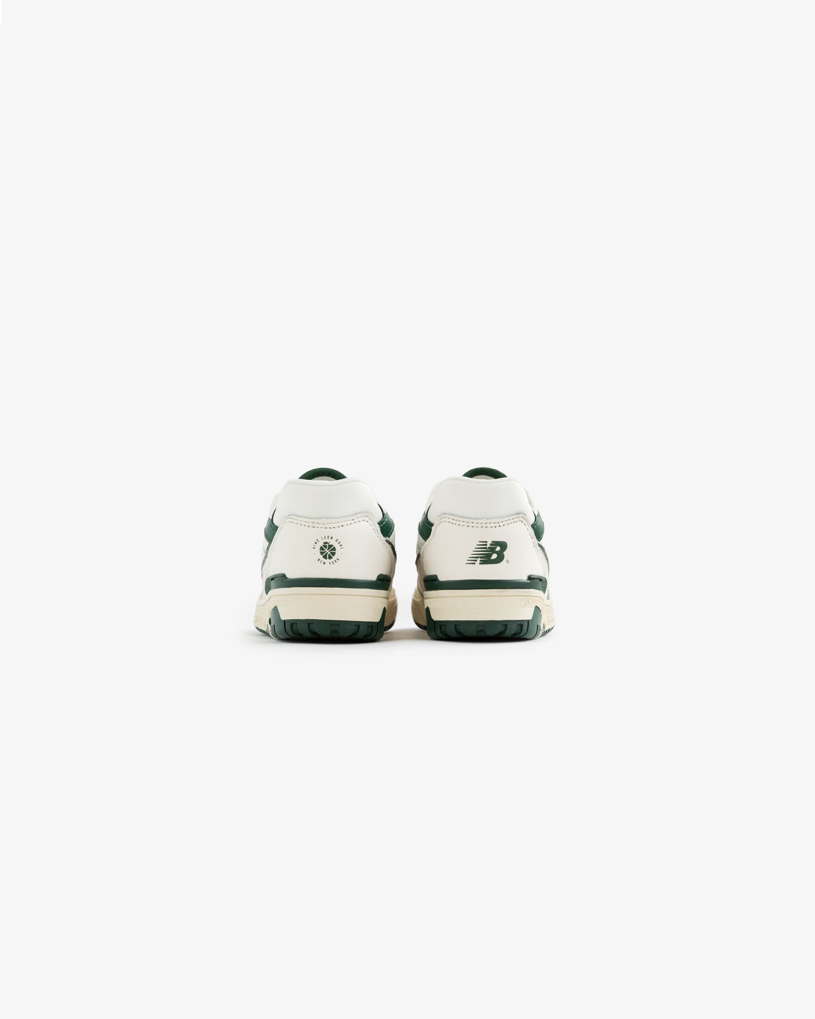 Back view of white and green ALD / NB P550 Basketball Oxfords for little kids on a plain white background.