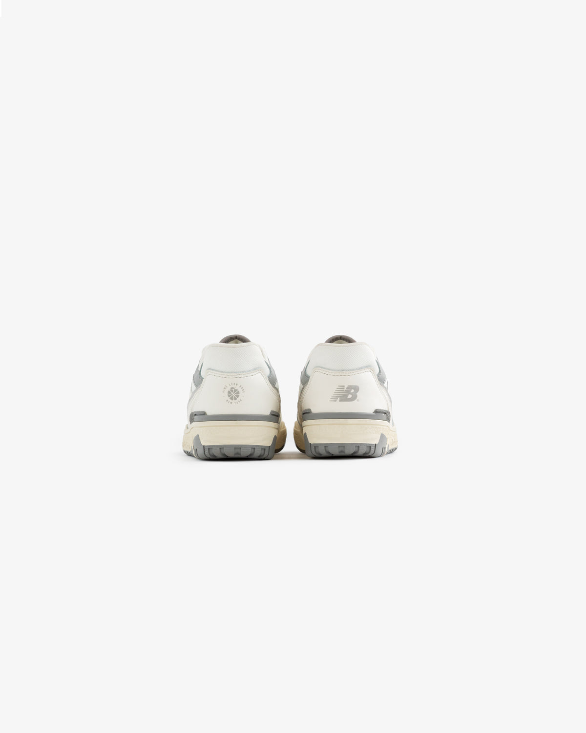 Rear view of ALD / NB P550 Basketball Oxfords for little kids in white and gray, logos on the heels, white background.