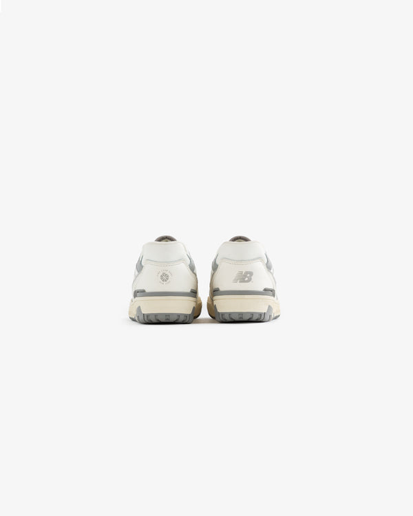 Rear view of ALD / NB P550 Basketball Oxfords for little kids in white and gray, logos on the heels, white background.