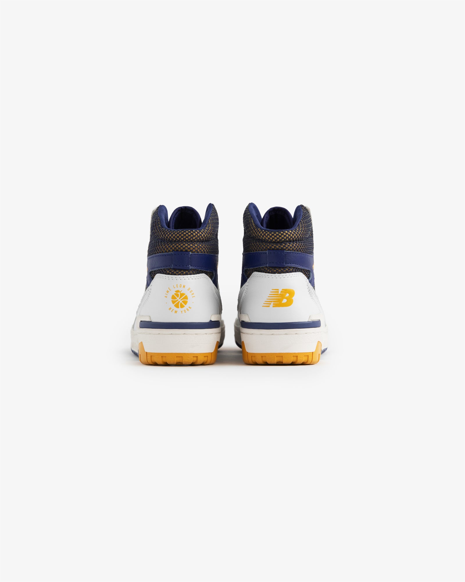 Back view of ALD / New Balance 650R sneakers in white, blue, and yellow with heel logos on a white background.