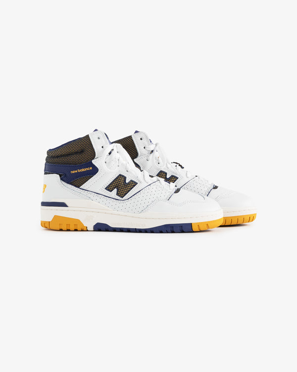 ALD / New Balance 650R sneakers in white and navy with yellow accents, mesh details, and gum soles on white background.