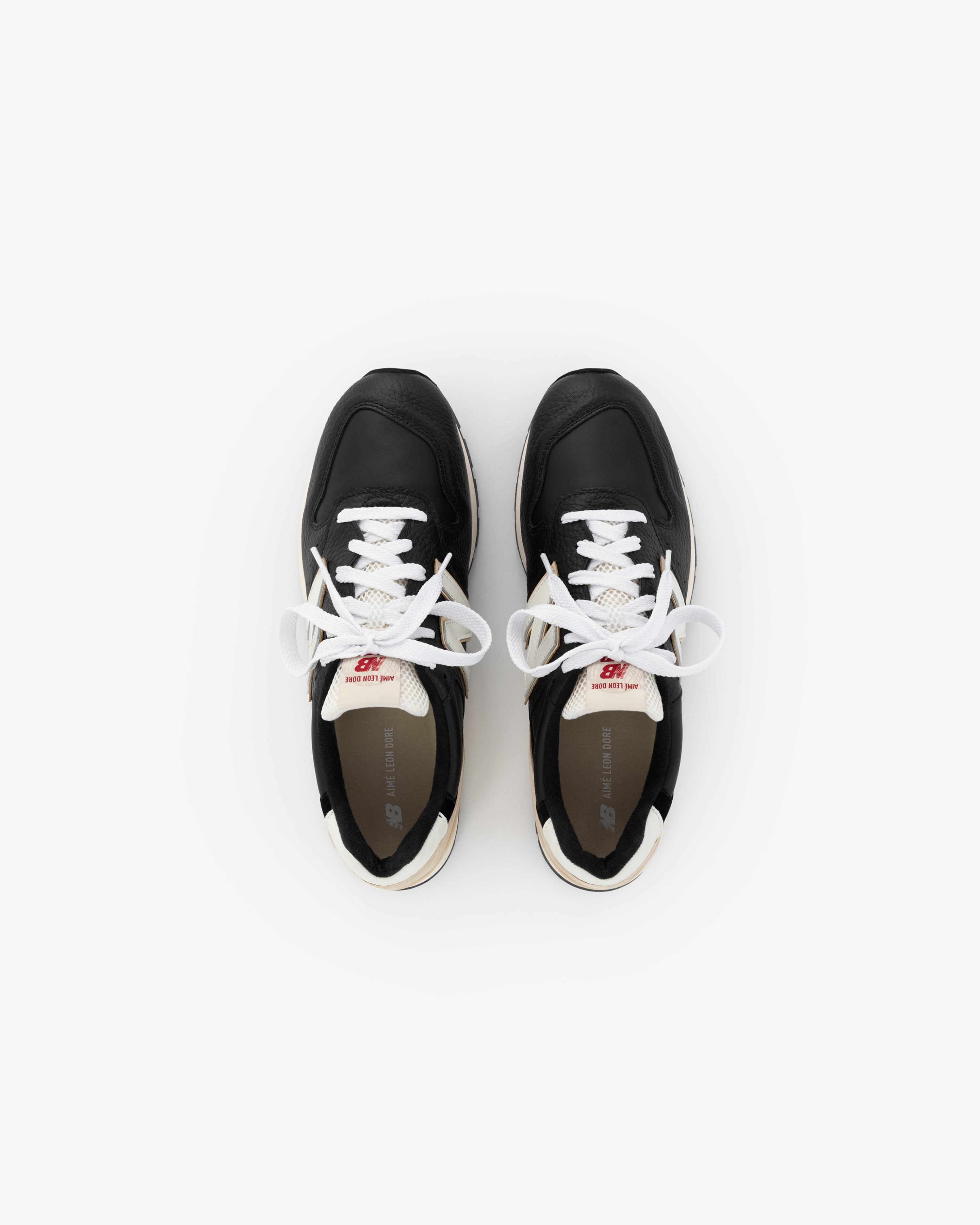 The ALD / NB Made in USA 996 sneakers are black with white laces, shown from above on a white background.