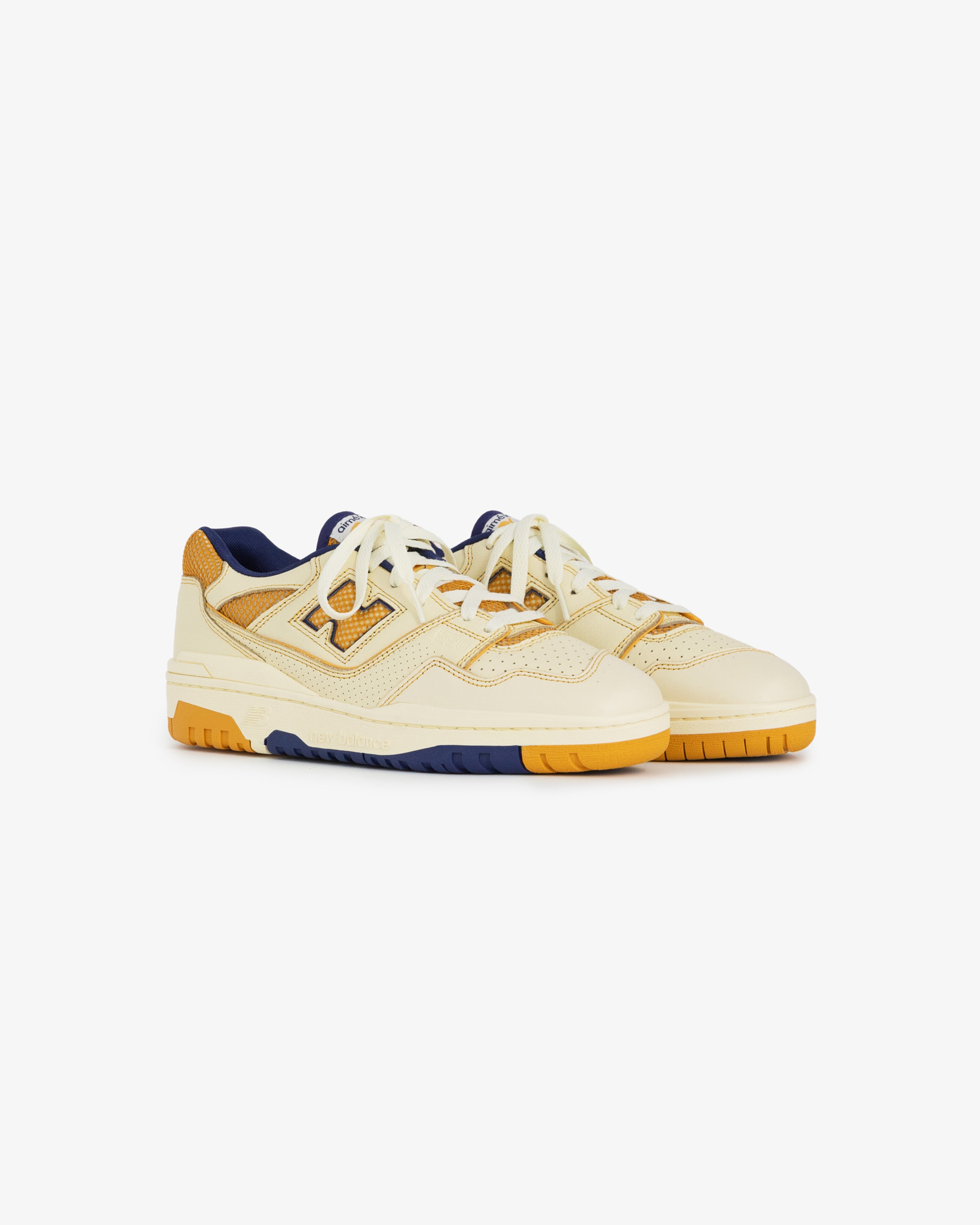 ALD / NB P550 Basketball Oxfords in yellow and cream with blue and orange accents, shown on a white background.
