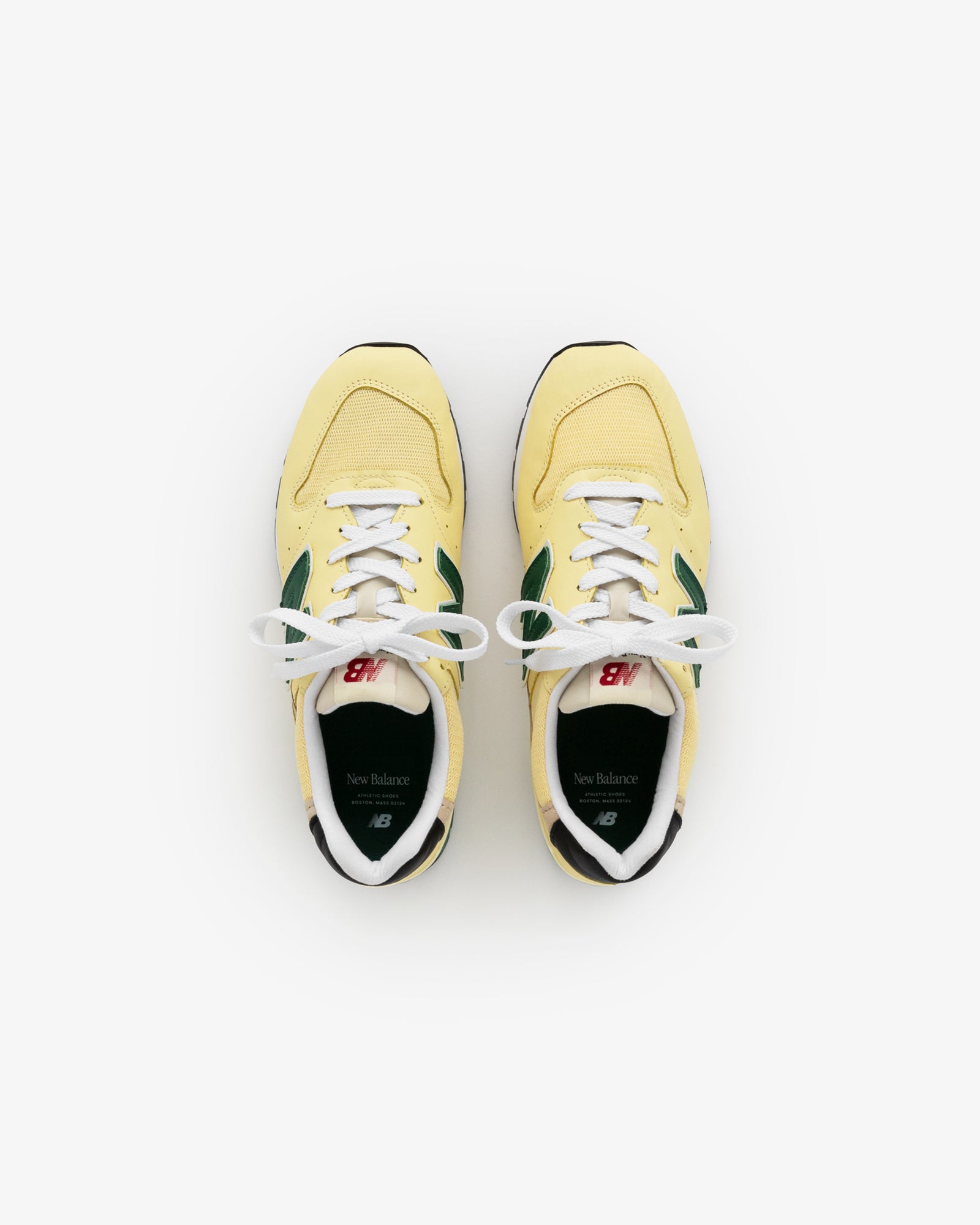 A pair of yellow and green New Balance Made in USA 996 sneakers viewed from above on a white background.