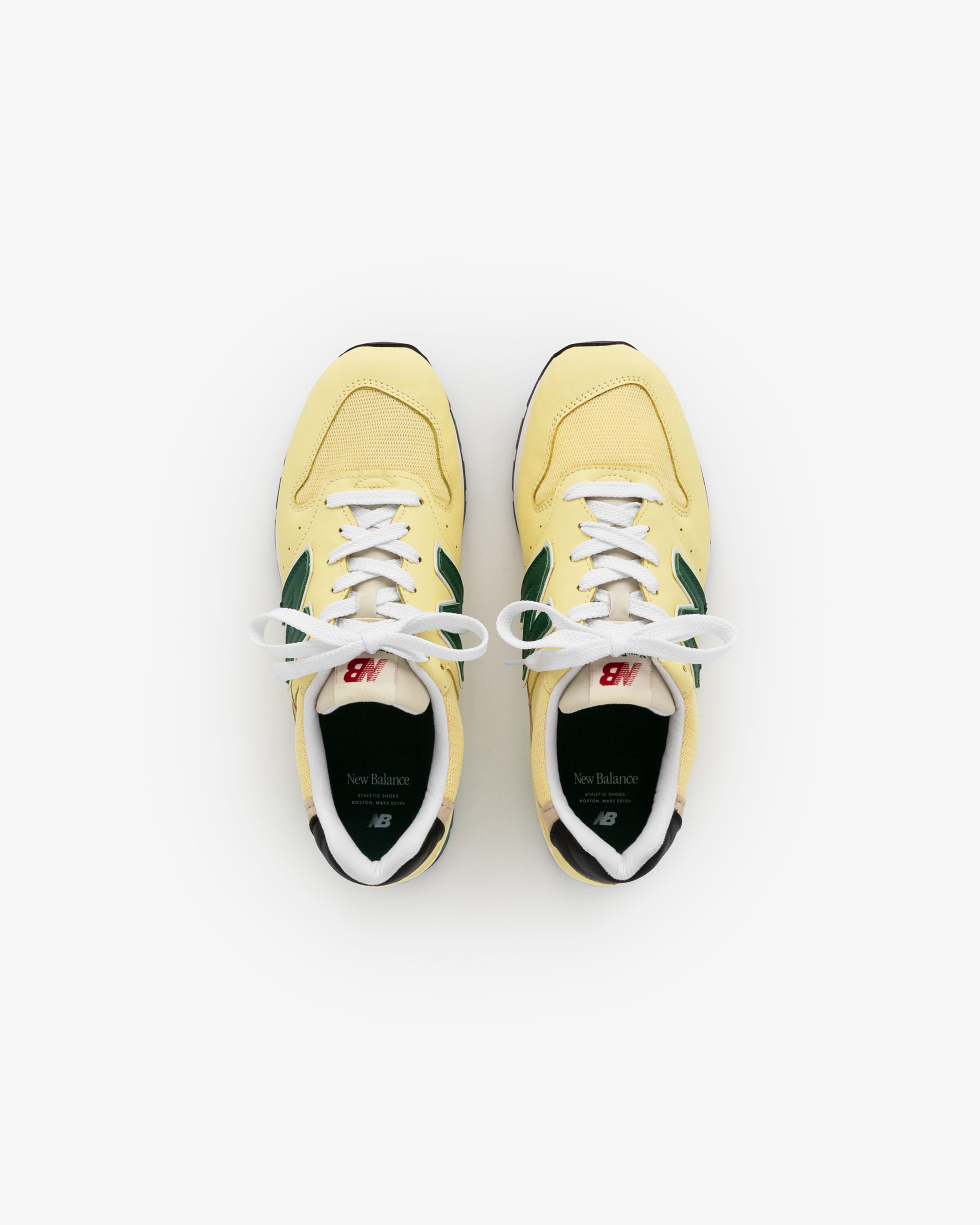 A pair of yellow and green New Balance Made in USA 996 sneakers viewed from above on a white background.