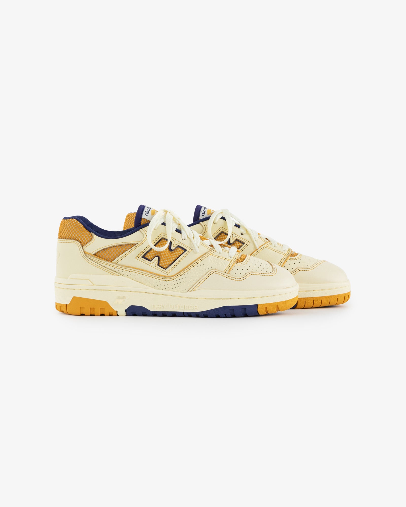 ALD / NB P550 Basketball Oxfords in yellow and orange with navy accents, white laces on a white background.