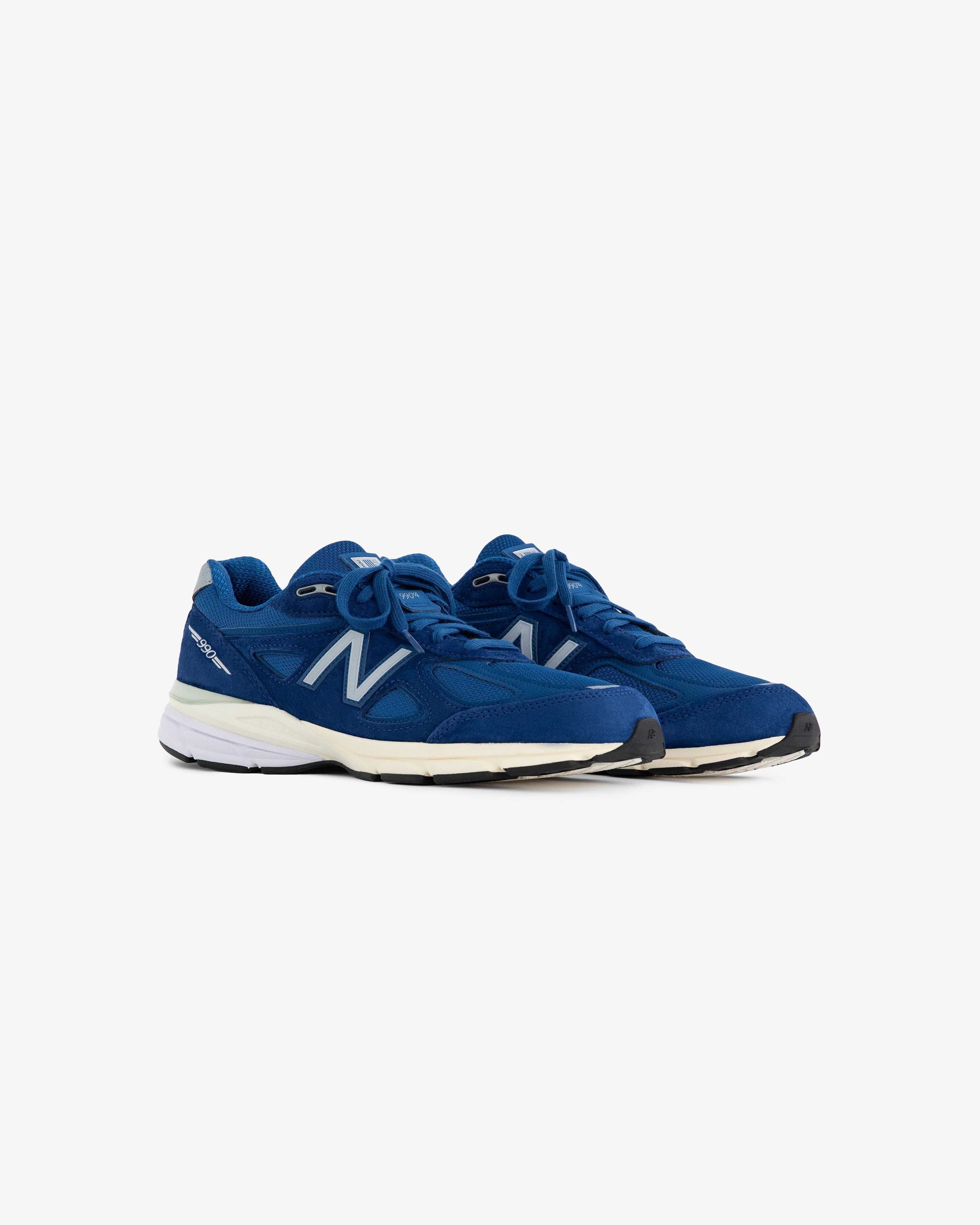 A pair of ALD / NB Made in USA 990v4 sneakers with white soles, viewed at an angle on a white background.