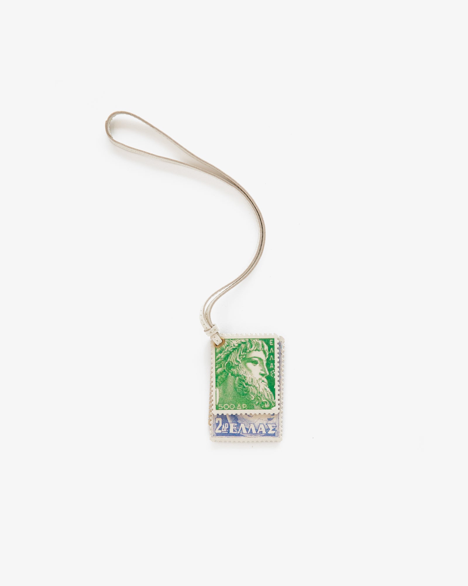 A Leather Traveler Charm with a green and blue Greek stamp pendant and silver loop, shown on a white background.