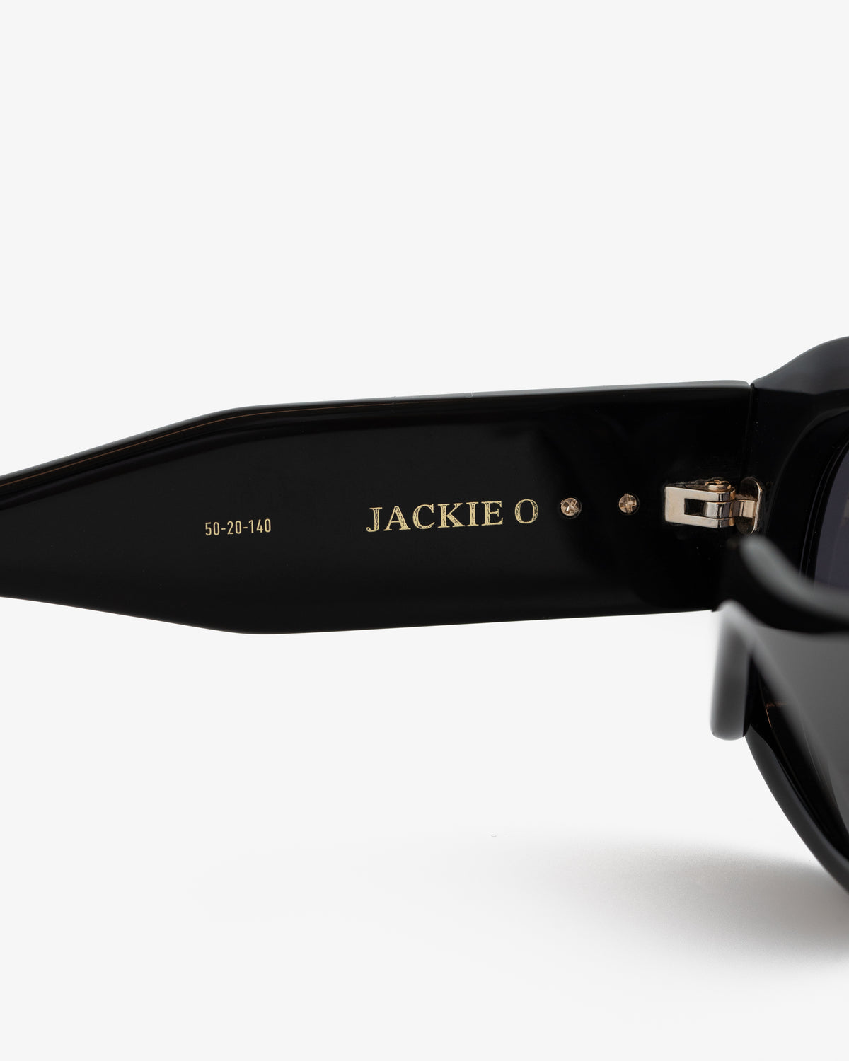 Close-up of Jackie O Sunglasses' black arm with gold branding and size numbers printed inside.