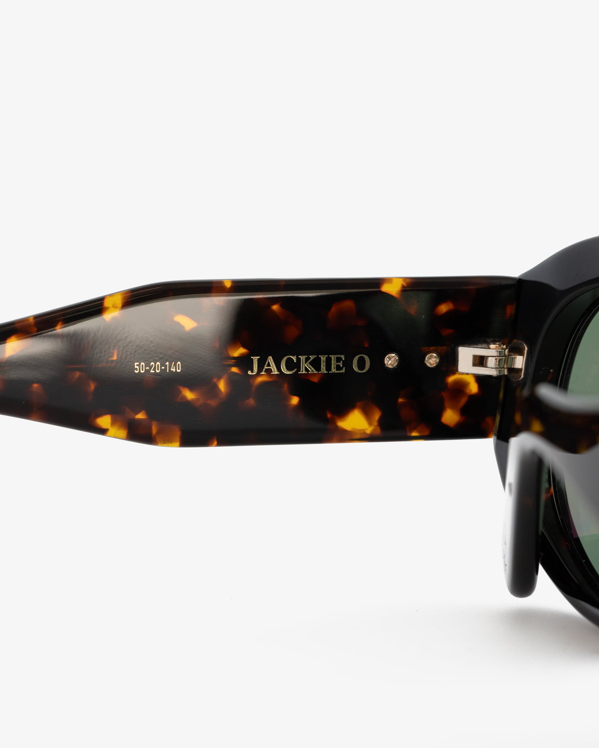 Close-up of Jackie O Sunglasses arm featuring gold lettering of brand and size on the inside tortoiseshell frame.