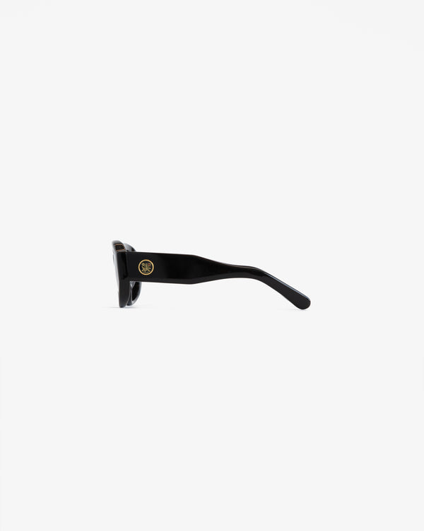 Jackie O Sunglasses shown from the side, with thick arms and a small gold logo by the hinge on a white background.