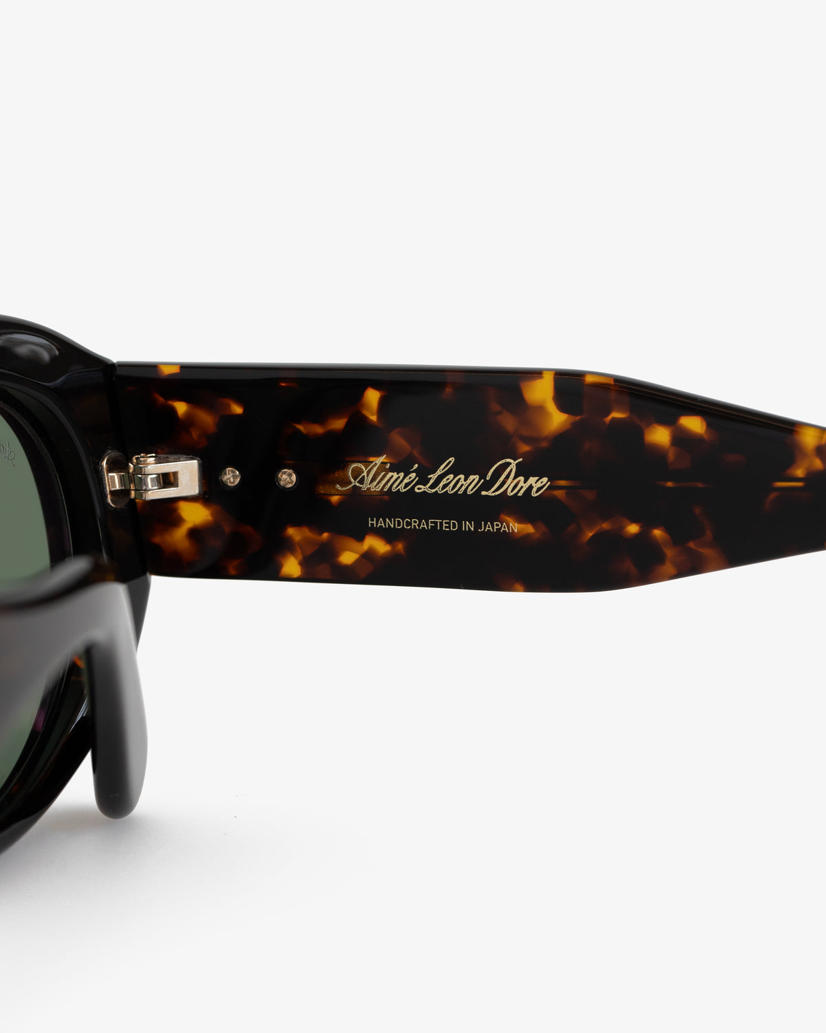 Close-up of Jackie O Sunglasses arm with gold Aimé Leon Dore HANDCRAFTED IN JAPAN text.