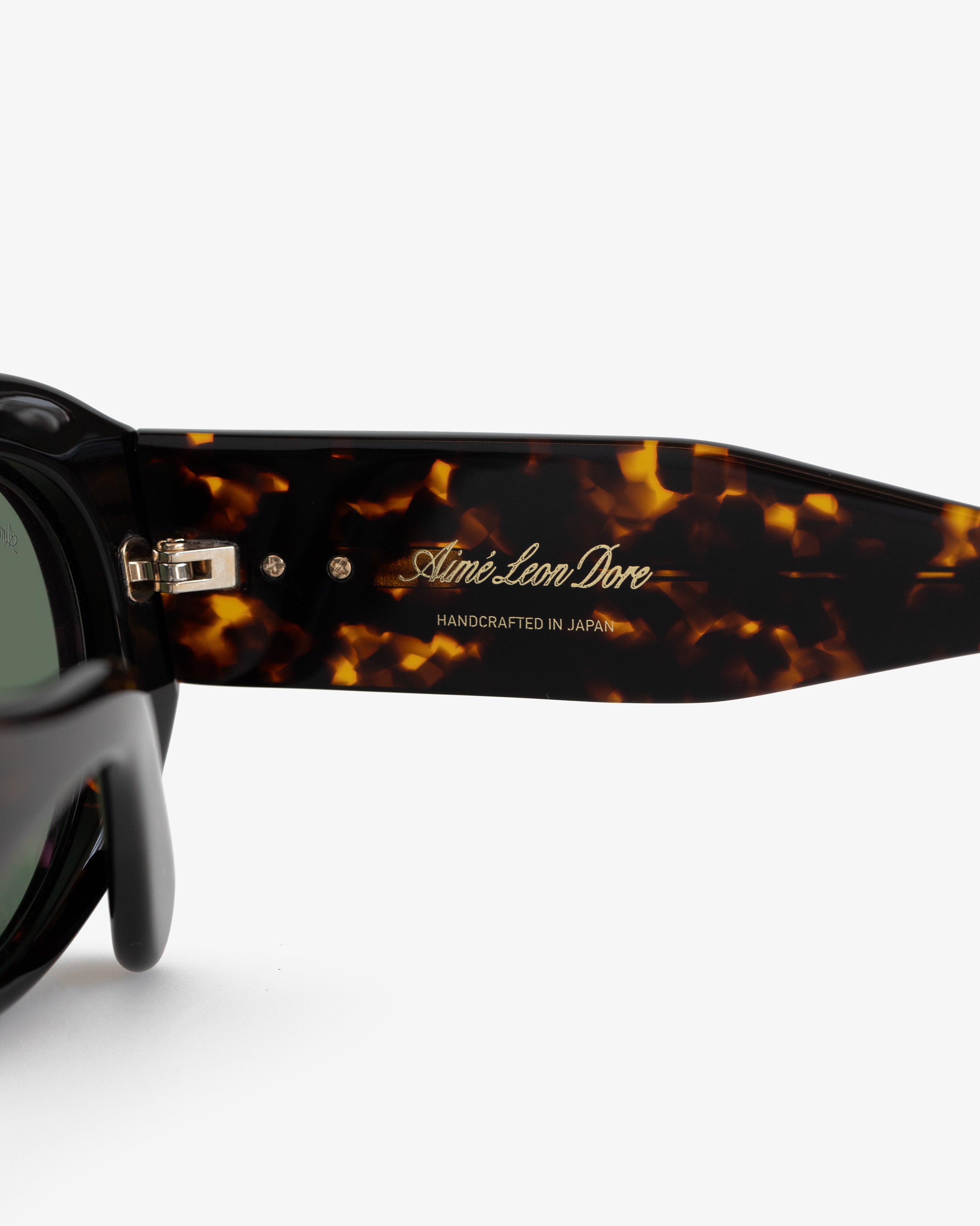 Close-up of Jackie O Sunglasses arm with gold Aimé Leon Dore HANDCRAFTED IN JAPAN text.
