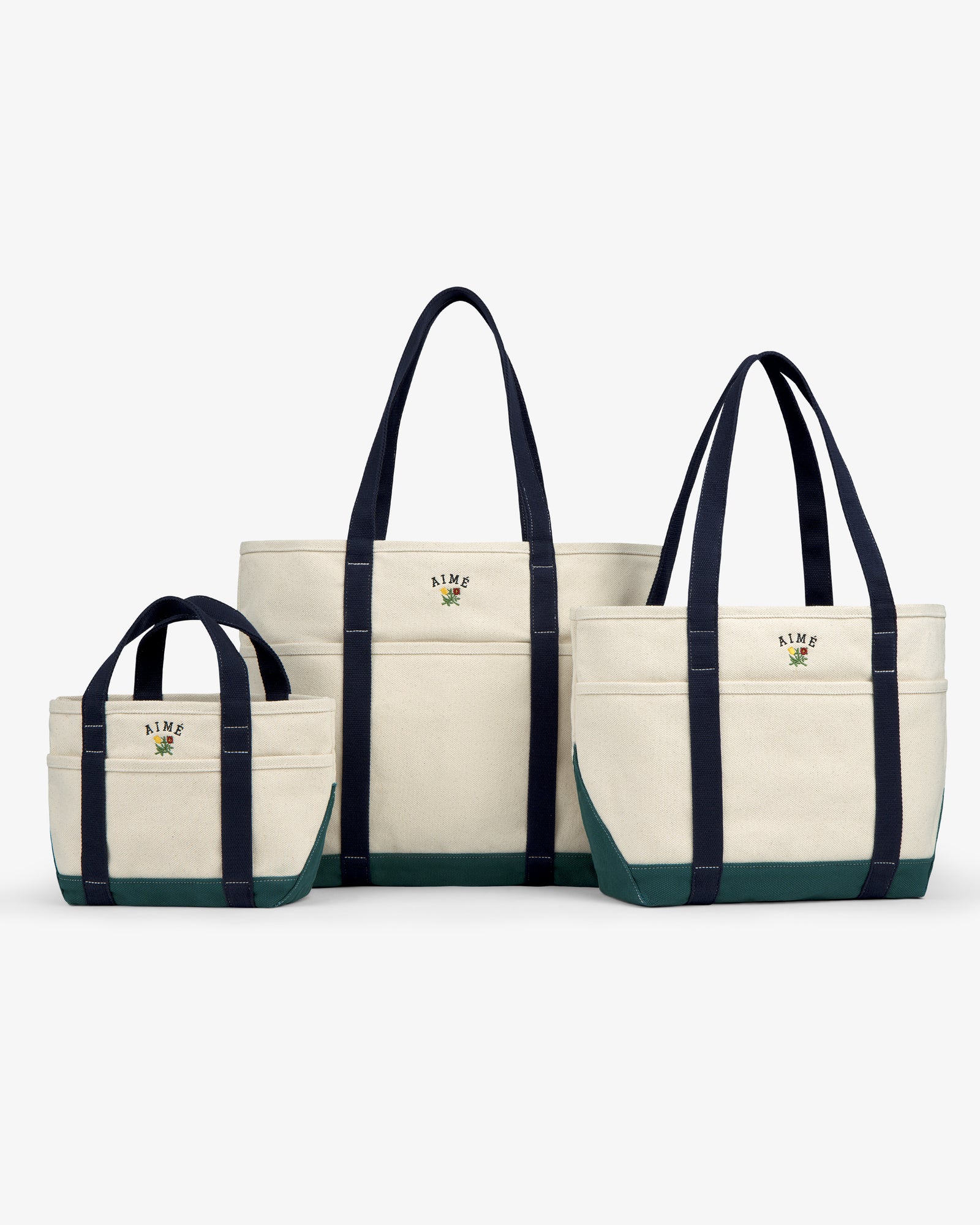 Three Mini Crest Contrast Tote Bags in various sizes, navy handles, green bottoms, displayed on a white background.