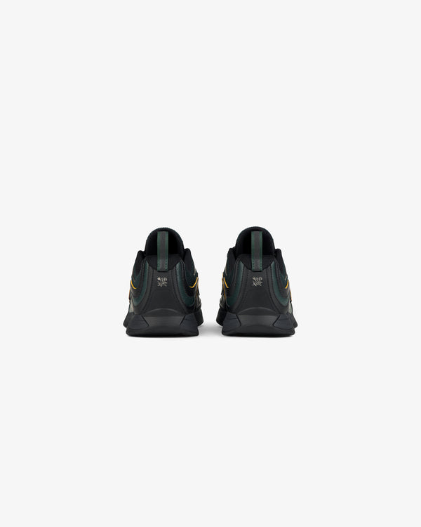 ALD / New Balance RC56 black sneakers with green and yellow accents, shown from the back on a white background.