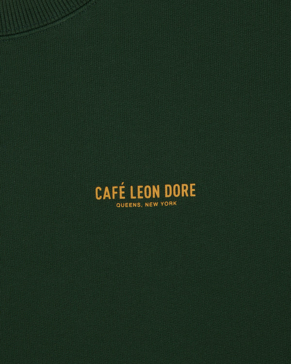 Dark green Café Leon Dore Crewneck Sweatshirt with yellow "CAFÉ LEON DORE QUEENS, NEW YORK" text at center.