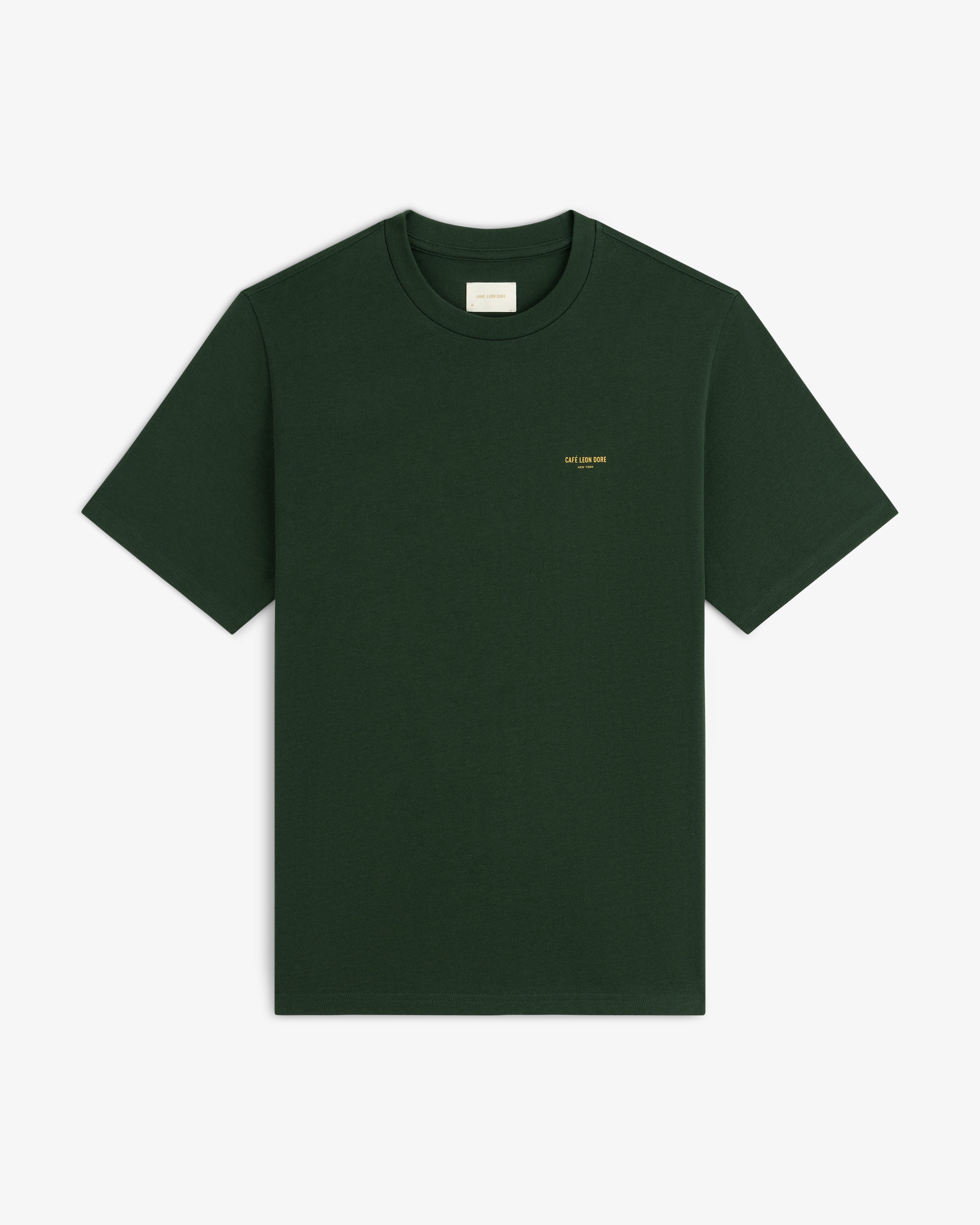 Café Leon Dore Logo Tee in dark green with small yellow chest text, shown on a plain white background.