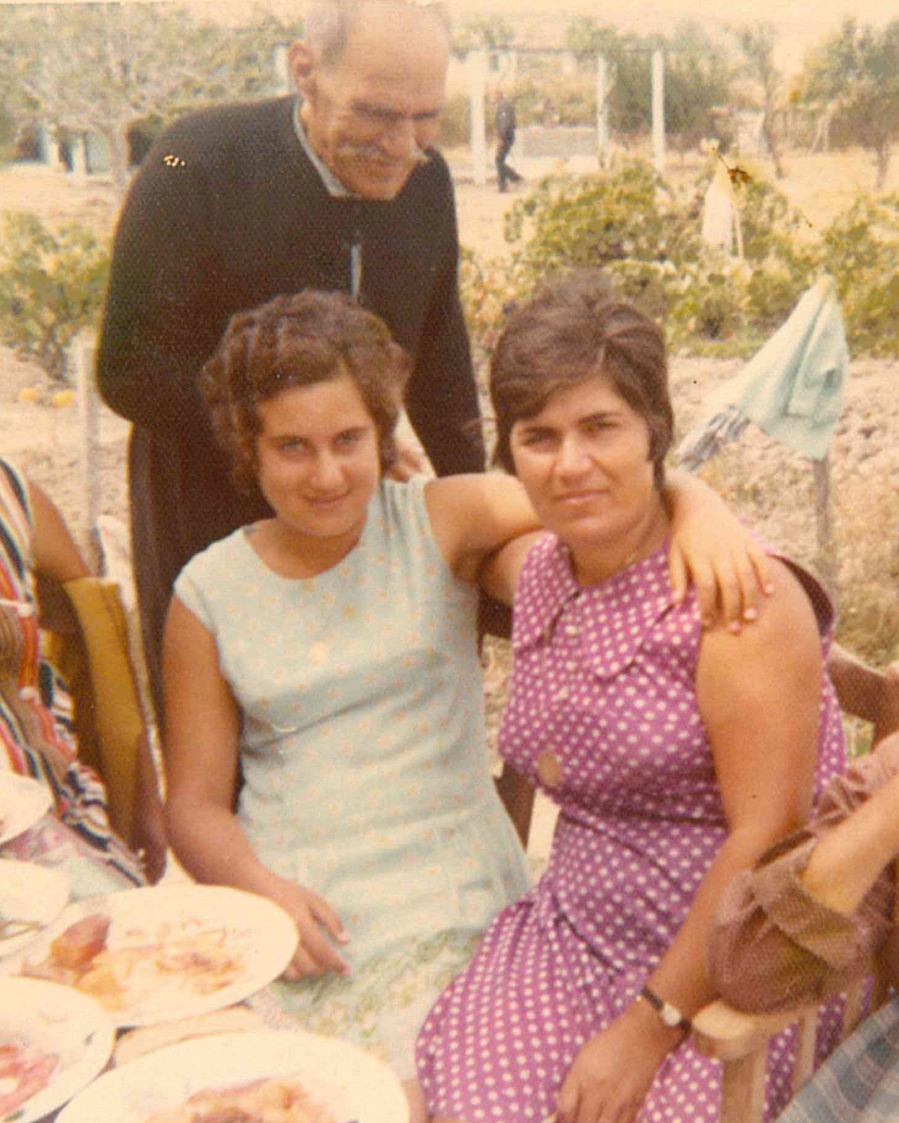 Two women posing for photo at outdoor dining table 