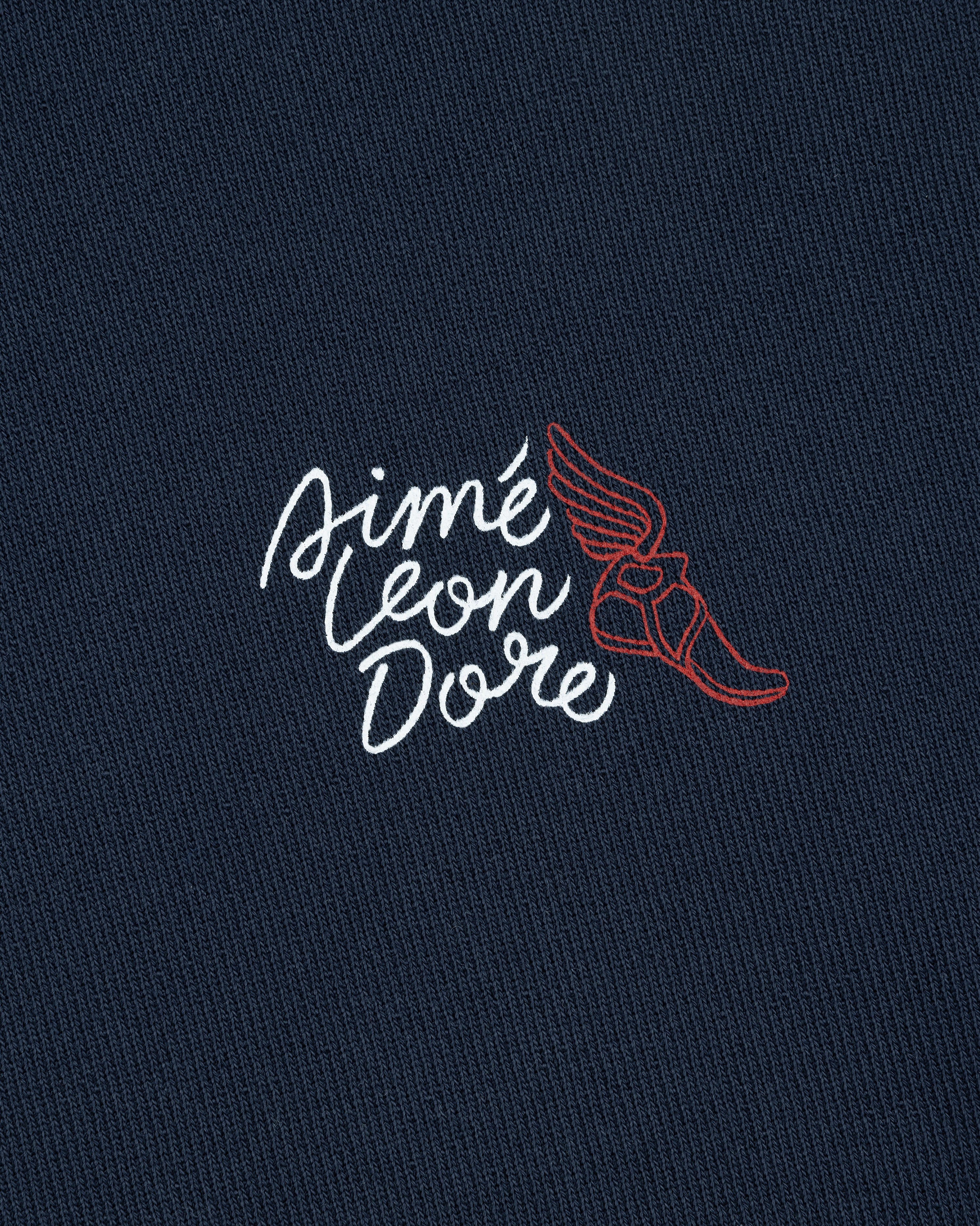 Navy Wingfoot Track Hoodie with white Aimé Leon Dore text and a red winged shoe graphic embroidered above.