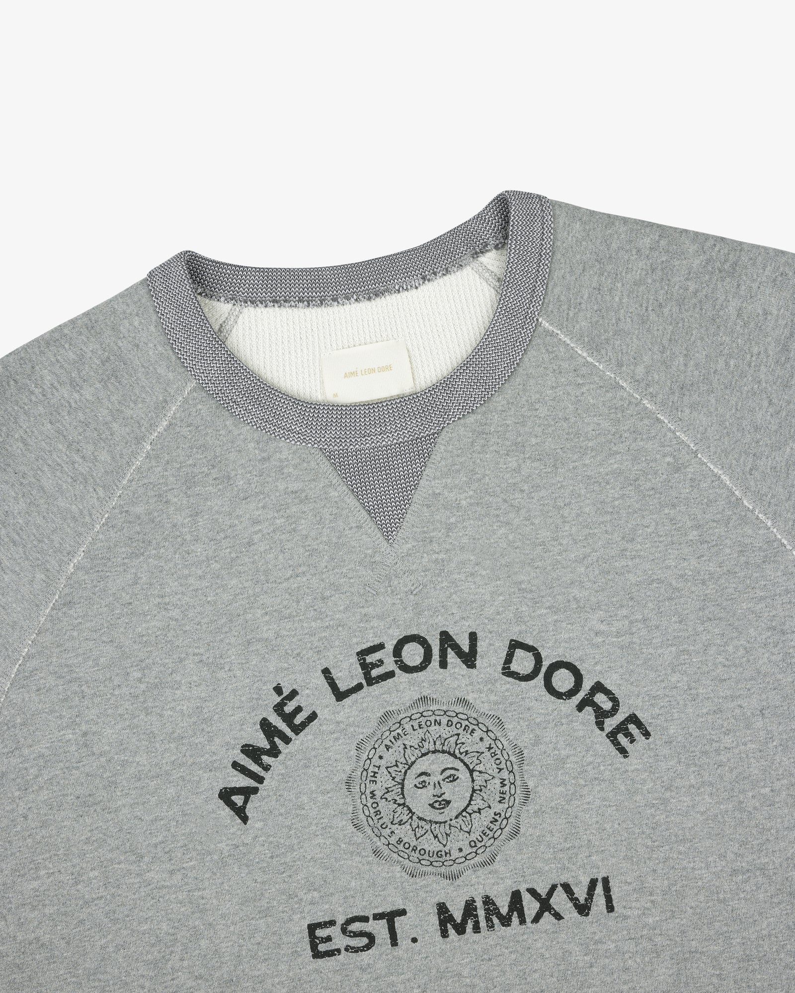 Souvenir Crewneck Sweatshirt in gray with Aimé Leon Dore EST. MMXVI and sun graphic on the front.